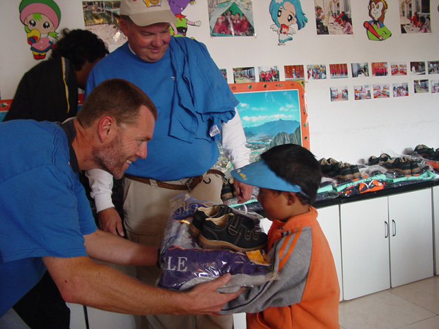 Scott handing out clothing at orphanage in Tibet