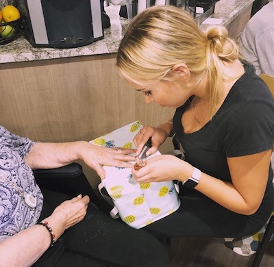 Kristina paints the nails of a senior at the center her chapter visits.