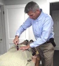Dr. Roddy using the Activator method to adjust a patient.