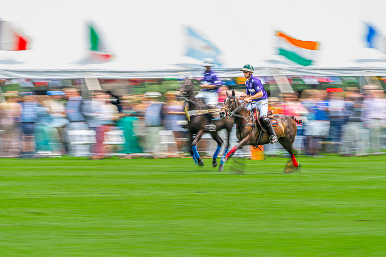 polo players battle it out in front of the grand stands at the mashomack polo club in pine plains, ny.  The action blur creats a sense of speed and movem.jpg