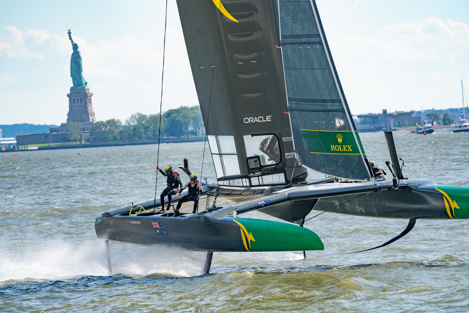 The crew of GB dancing around the deck of this Sail GP boat as shes riding her hydrofoils. The statue of liberty is in the background. Hudson river..jpg