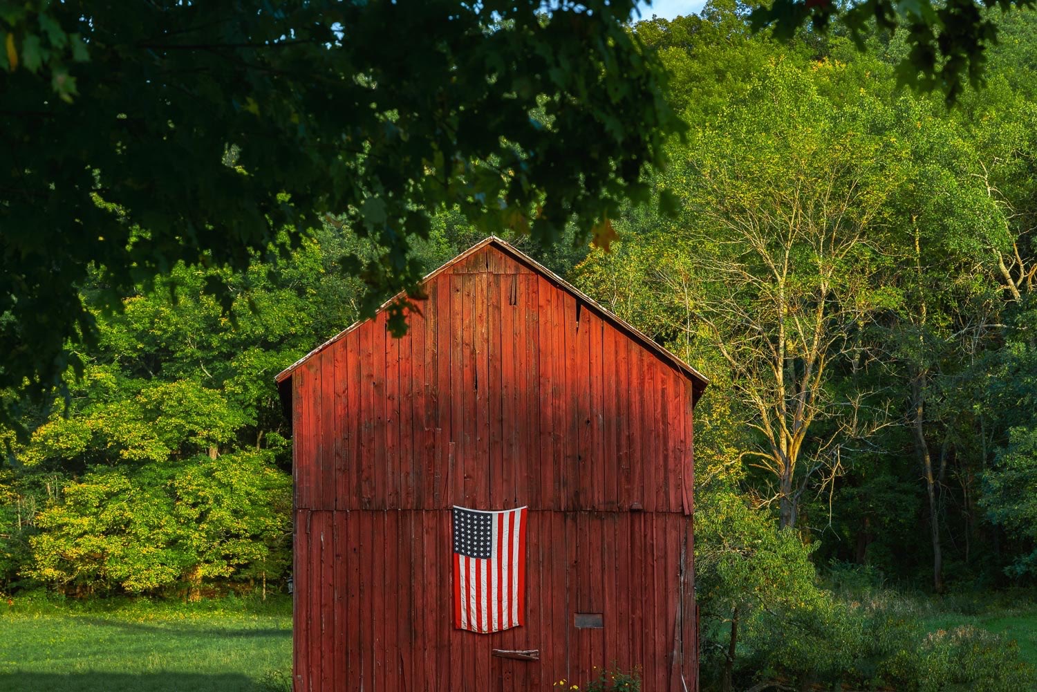 This historic barn glows in the autumn light. Its a piece of Americana with the american flag on the red barn.  johnstuartstudio-compress.jpg