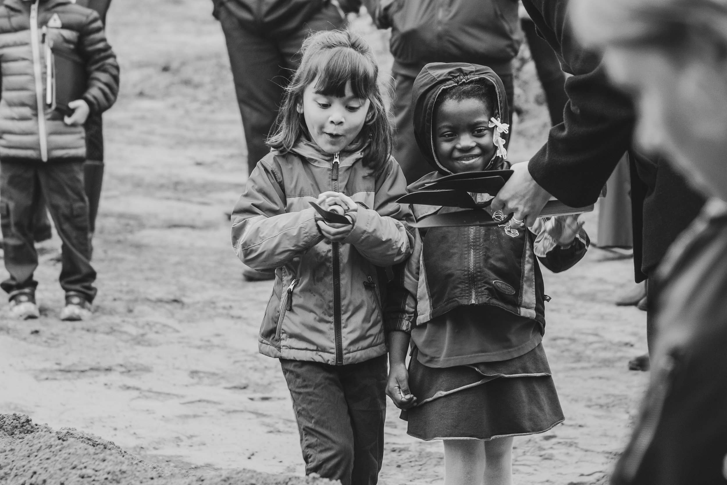 Two students carefully carry their groundbreaking shovels