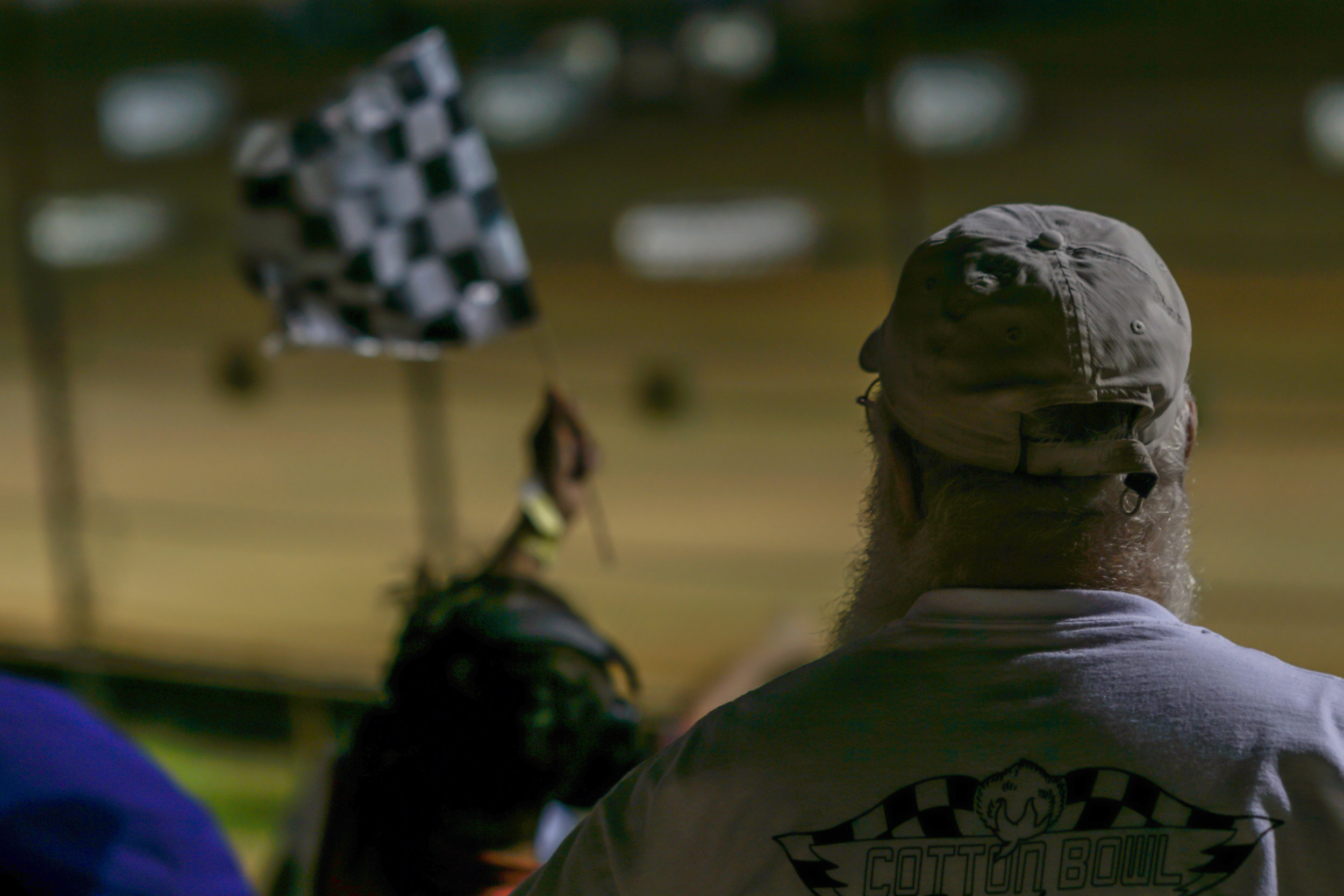 Spectator watches another fan waving the checkered flag