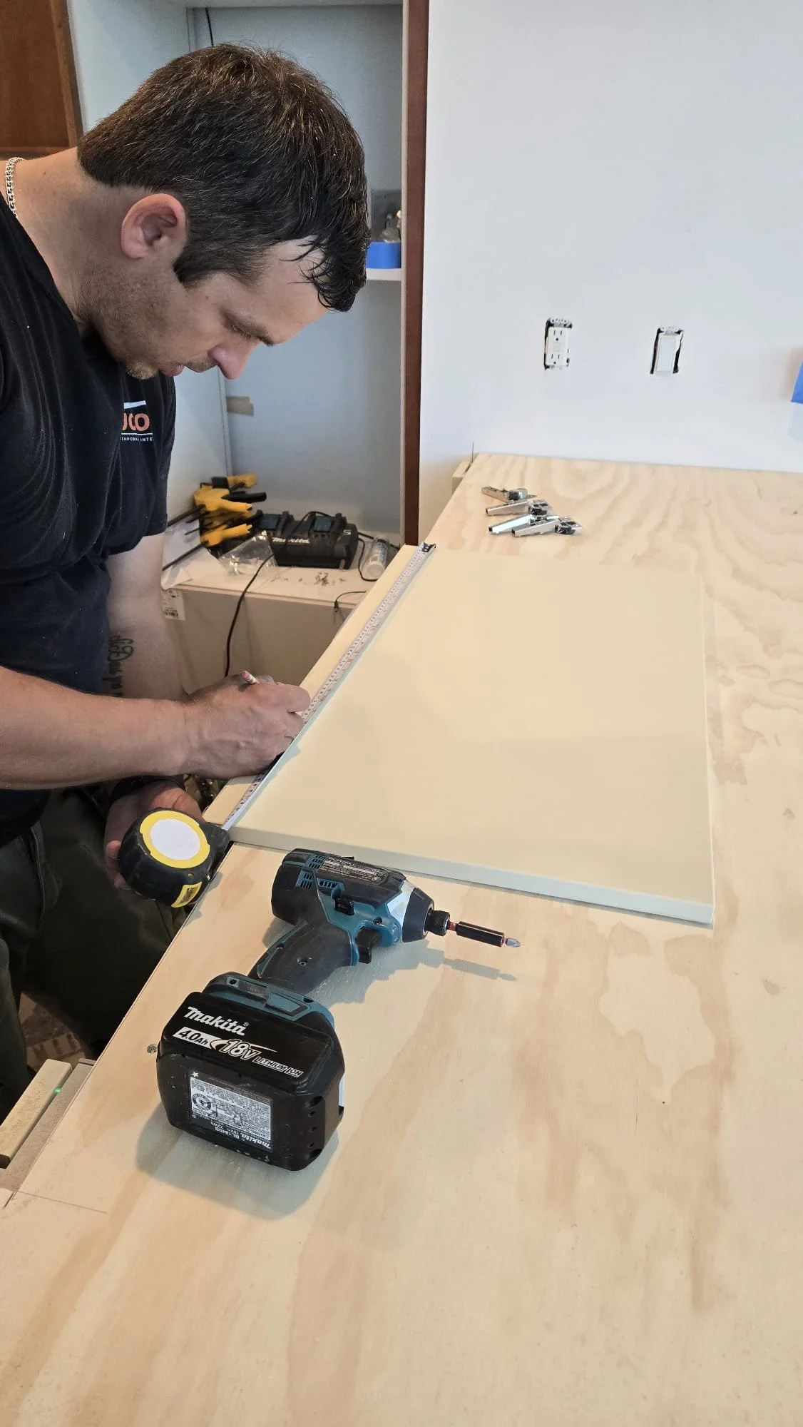 UCON installer measuring cabinetry components during field verification for a designer-led interior project.