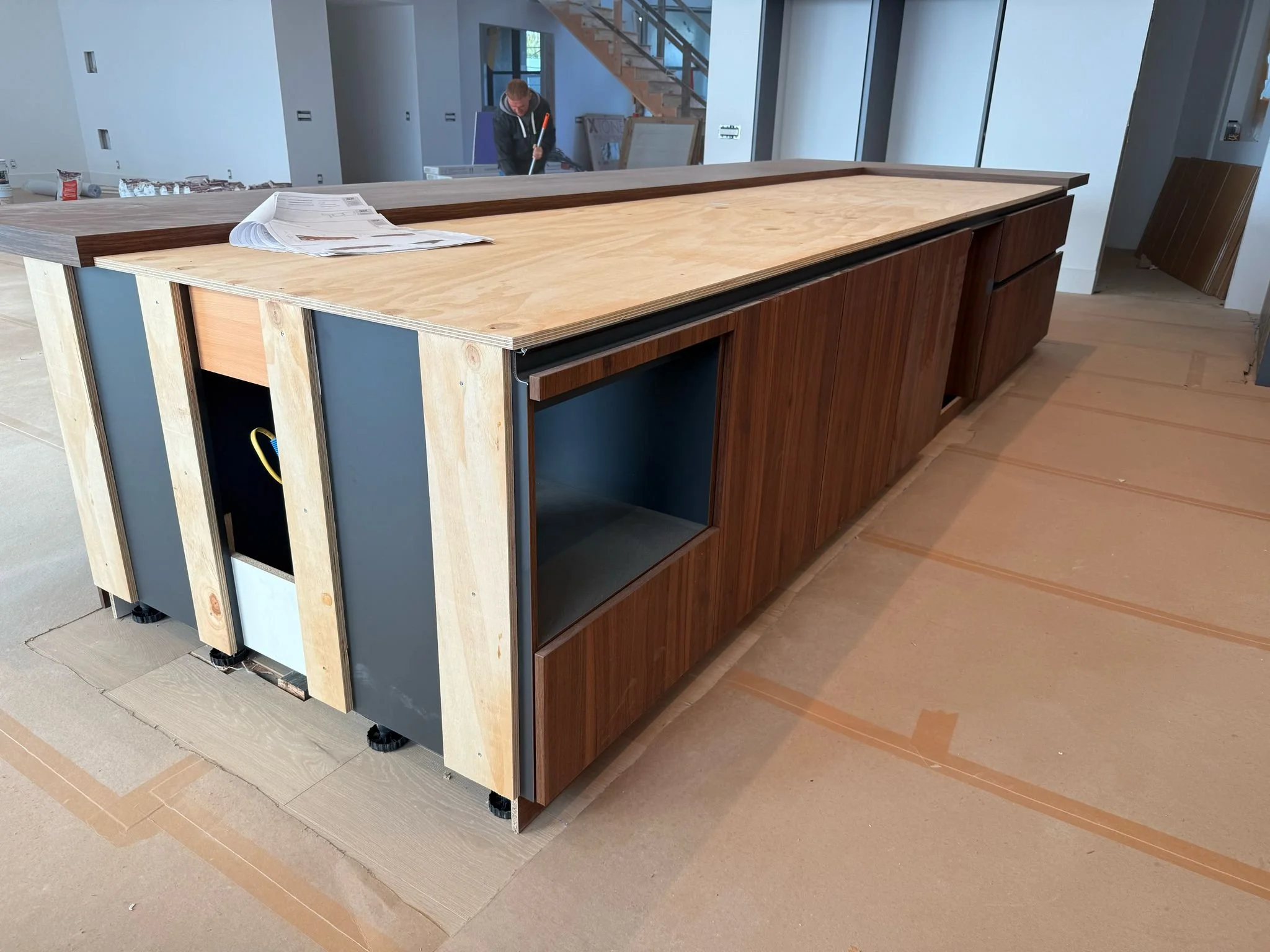 In-progress kitchen island and European cabinetry installation showing panel alignment, appliance coordination, and finish protection by UCON Contemporary Interiors.