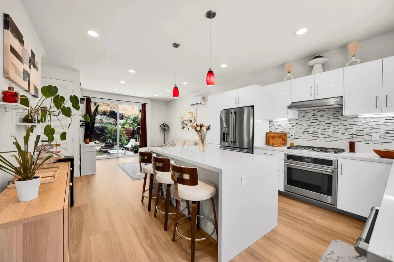 Finished contemporary kitchen at the Cantera multi-unit development in La Mesa, featuring white cabinetry and a central island.