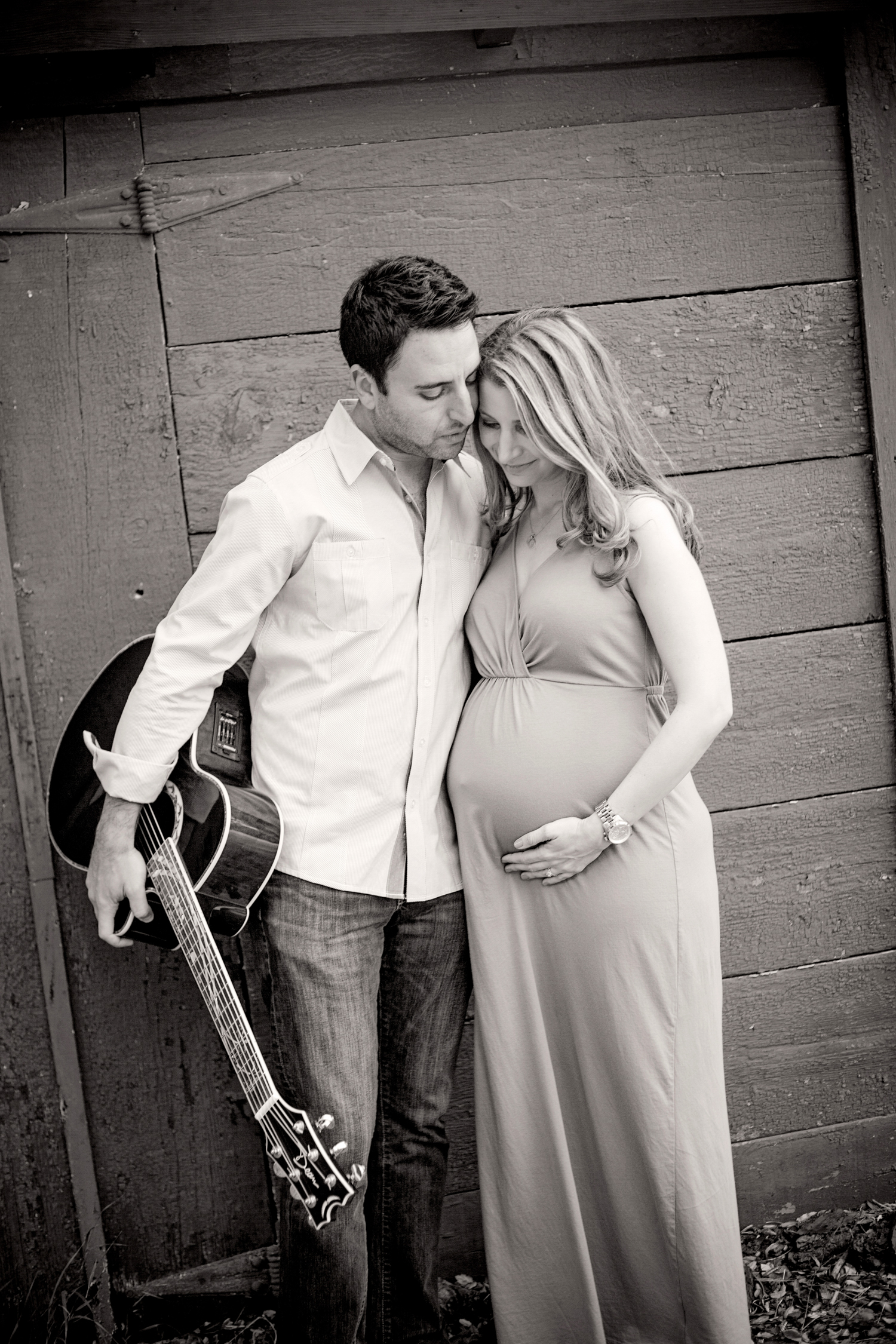 pregnant mom posing with dad holding his guitar