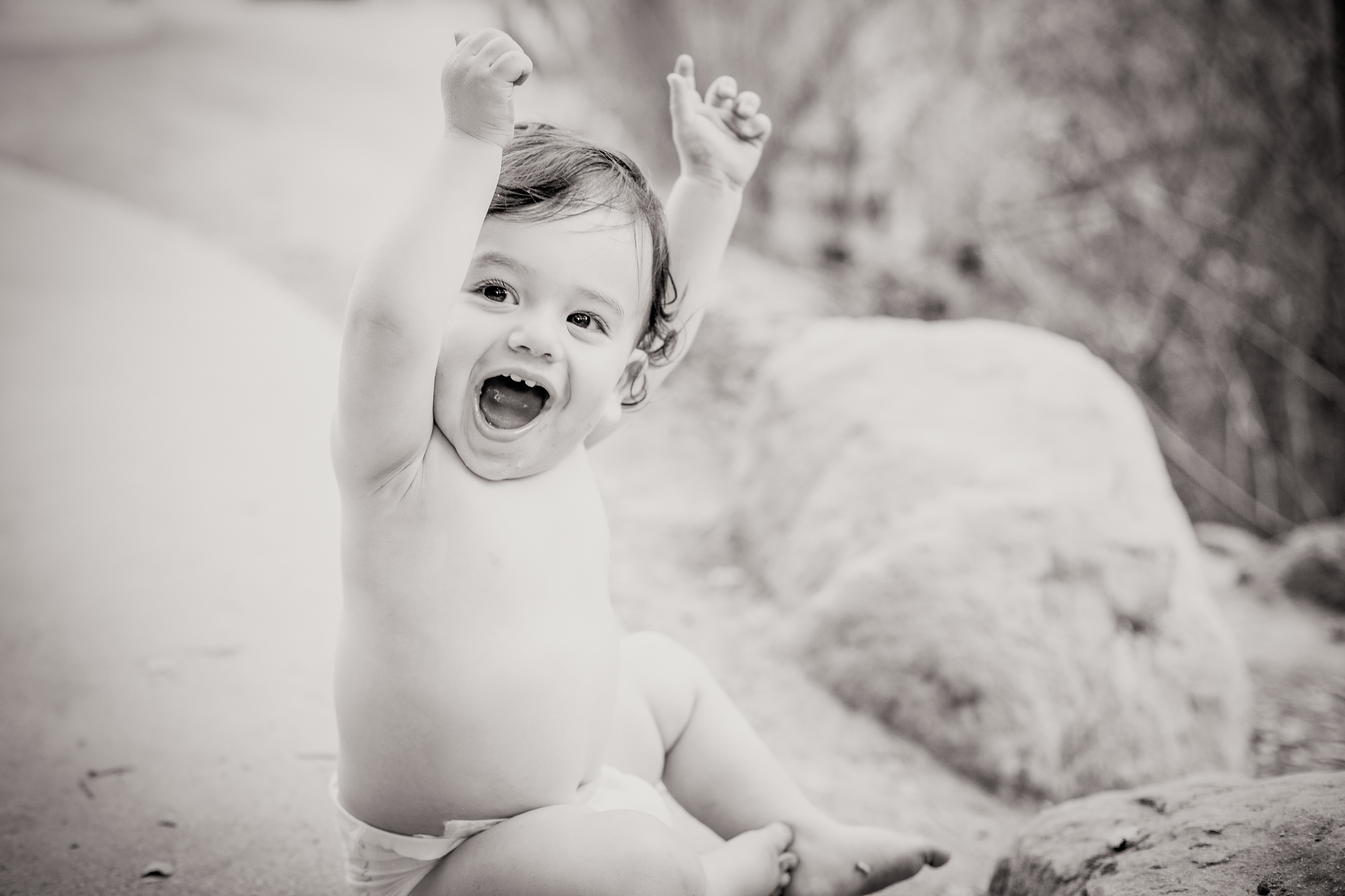 baby boy holding his arms over his head, looking victorious