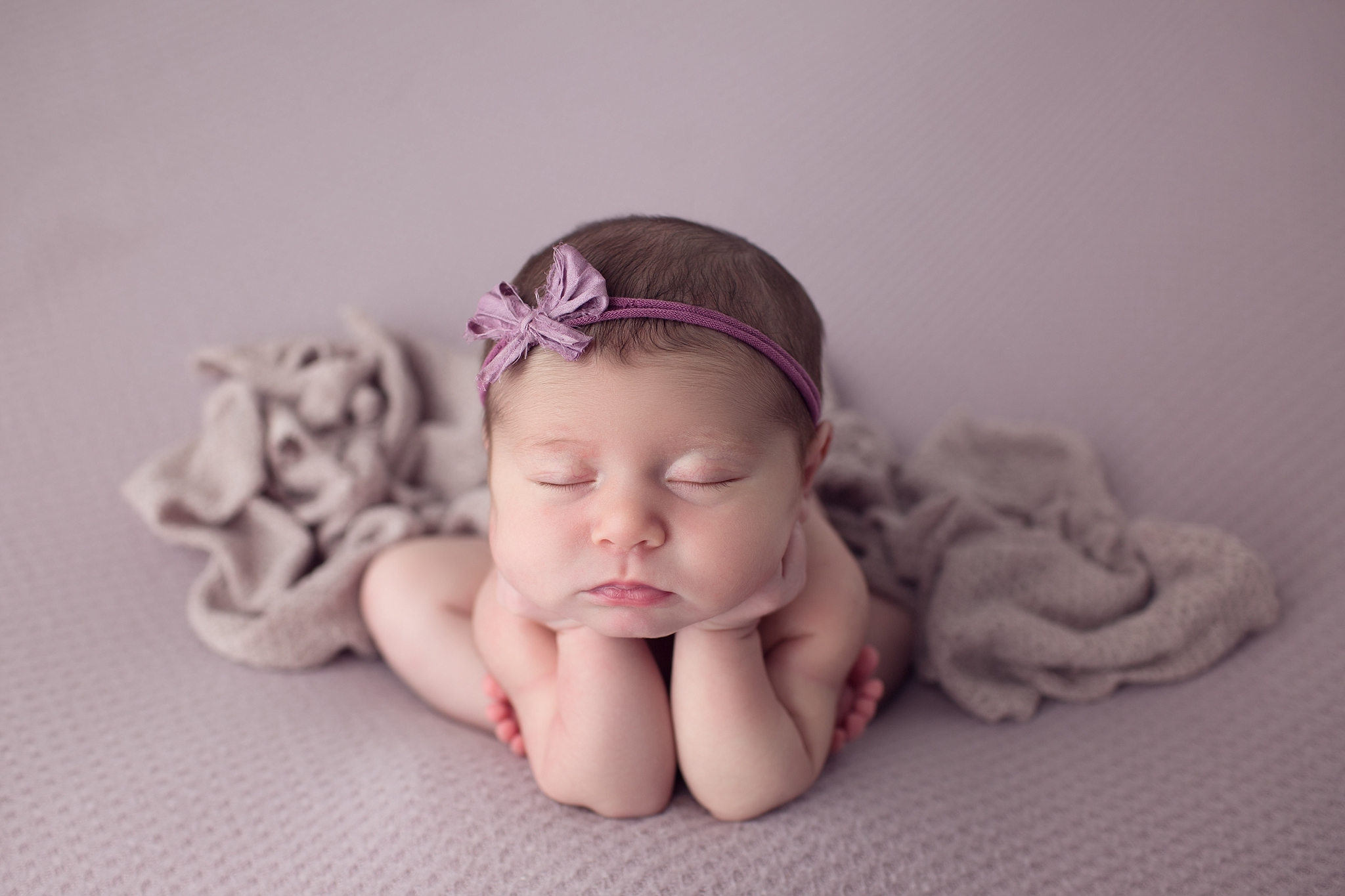 Baby girl resting on hands on lavender