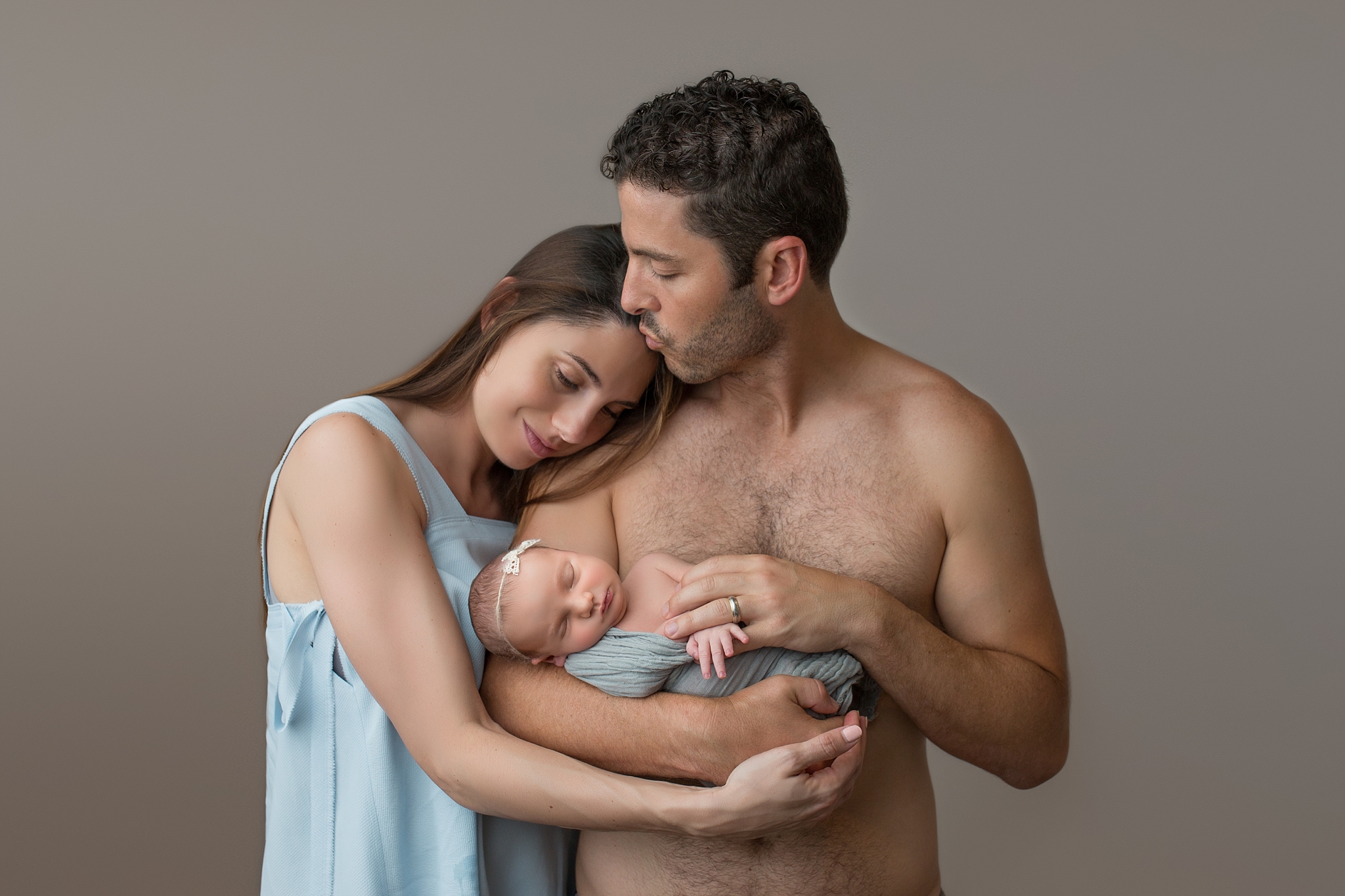 mom and dad with baby girl, hugging together