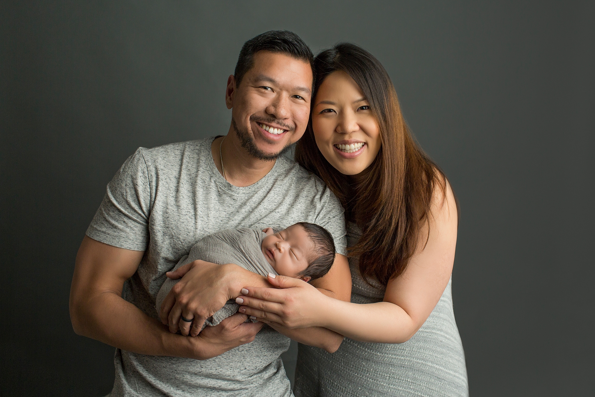 couple proudly holding their newborn