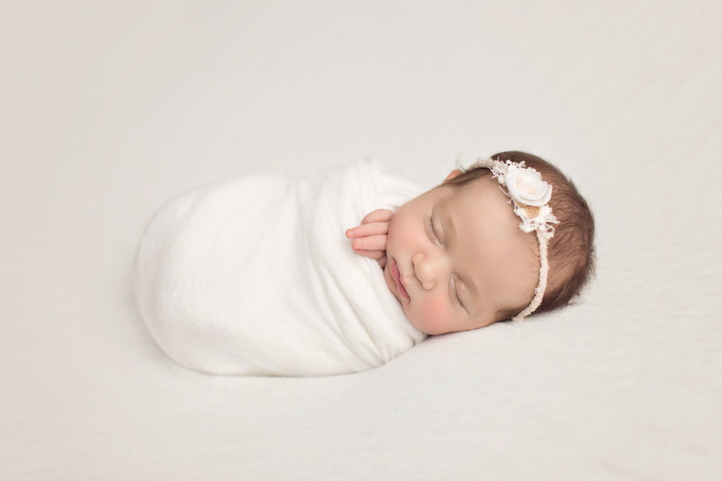 sweet baby girl sleeping while wrapped in white