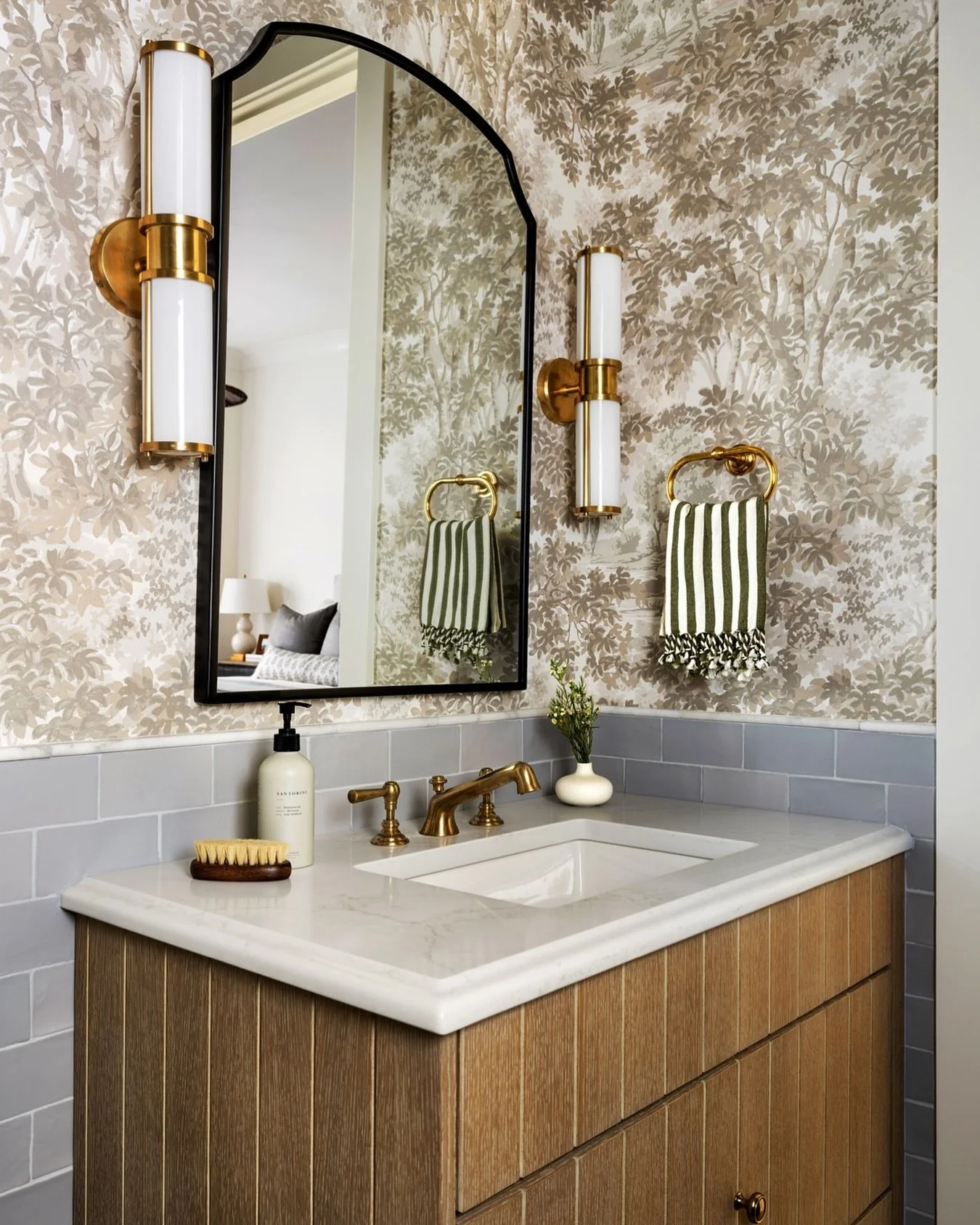 This &hellip;

What a powder bath! Every component was chosen with intention &mdash; from the oak vanity and soft gray tile to the tailored brass fixtures and statement wallpaper. 

It&rsquo;s a small space, but every detail was designed to make an i