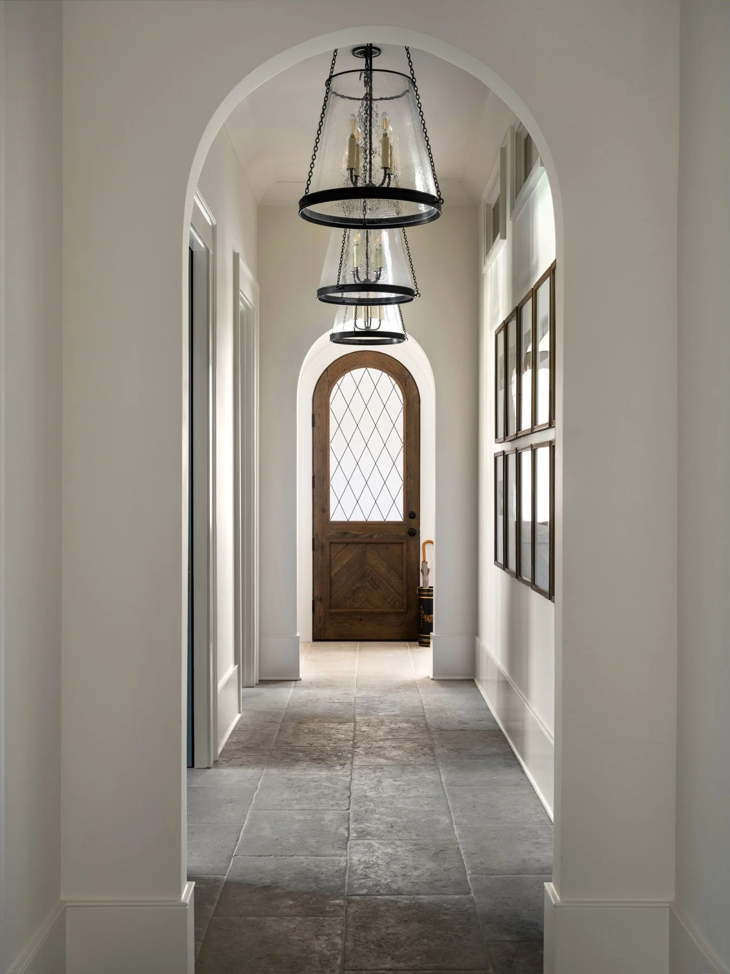 This serene little corridor leads to laundry, a powder bath, an office, and a handful of hidden gems waiting just beyond the archway 🤍

Timeless millwork, natural stone, and that warm wood door &mdash; all the ingredients for an inviting arrival.

?