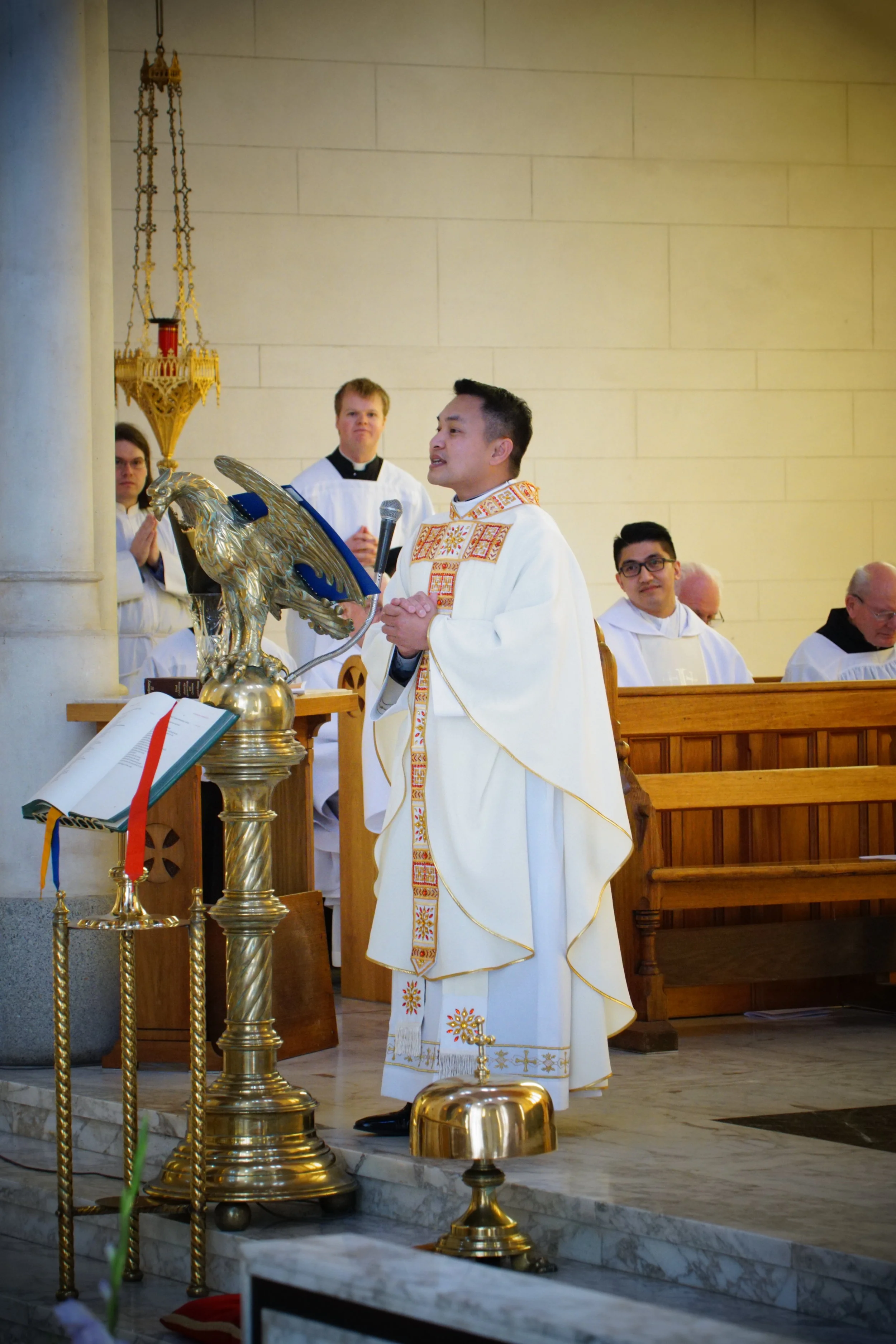 Fr Dean Bongat addresses the congregation after his ordination at the Cathedral as Fr Justel Callos looks on from behind. Picture: Joseph Nguyen.