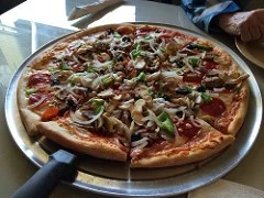 A freshly baked pizza displayed on a gleaming silver tray, highlighting its appetizing toppings and crust.