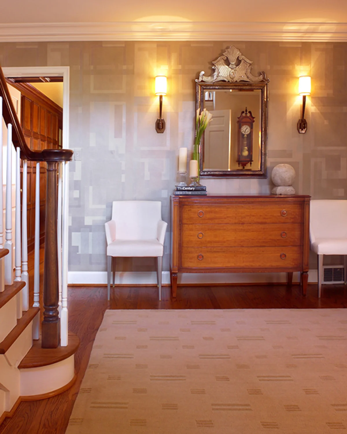 A foyer should make a statement and set a tone for the rest of the house; it’s the first thing guests see. We took cues from this home’s straight-lined Georgian colonial architecture, and made a focal wall of layered paper squares and rectangles. We contrasted it with sculptural pieces like the sconces and a Venetian mirror we found in San Francisco . More squares in the Tibetan rug and the contemporary Italian chairs flanking the Regency commode tie the space together.
