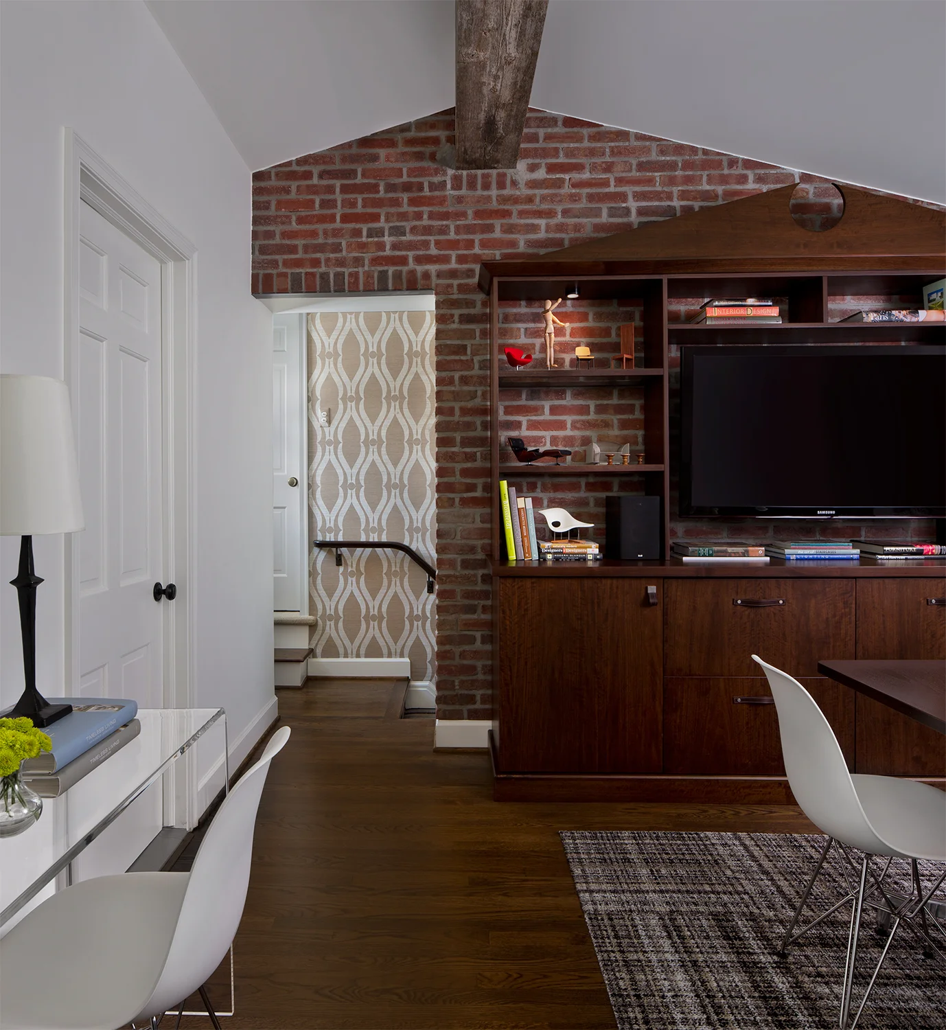 Layers of materials: A reclaimed barnwood beam, brick , walnut wood and patterned carpet and wallcovering add warmth.