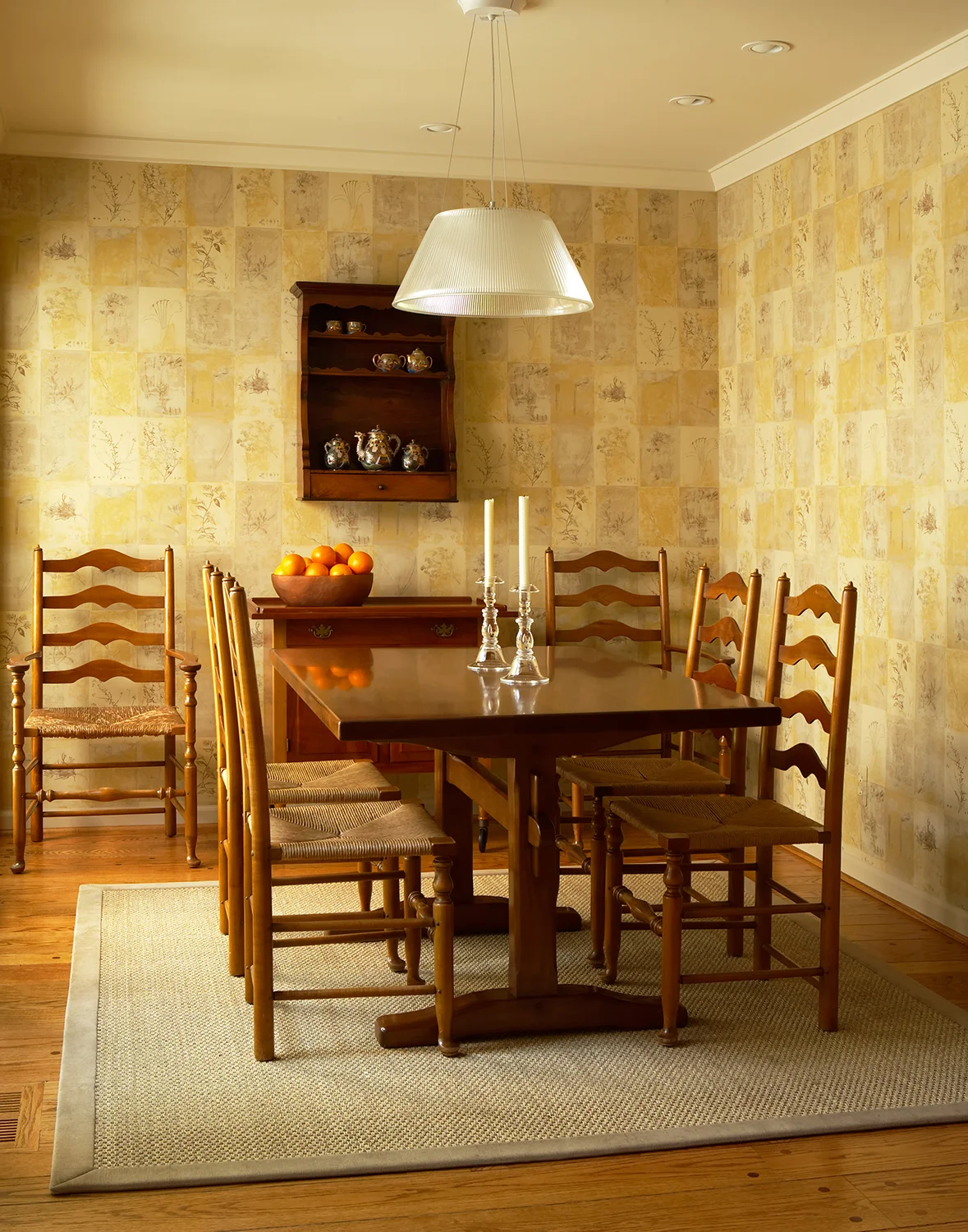 This breakfast nook is a study in simplicity, and how traditional and contemporary relate. Our clients loved their shaker table and chairs, and were thrilled when we said they worked in the new design. This room sits adjacent to the garden, so we had the walls covered in a block-printed botanical pattern, and then hung the very contemporary glass light over the table. The look is warm, traditional, and modern at the same time. Photo by Beth Singer.