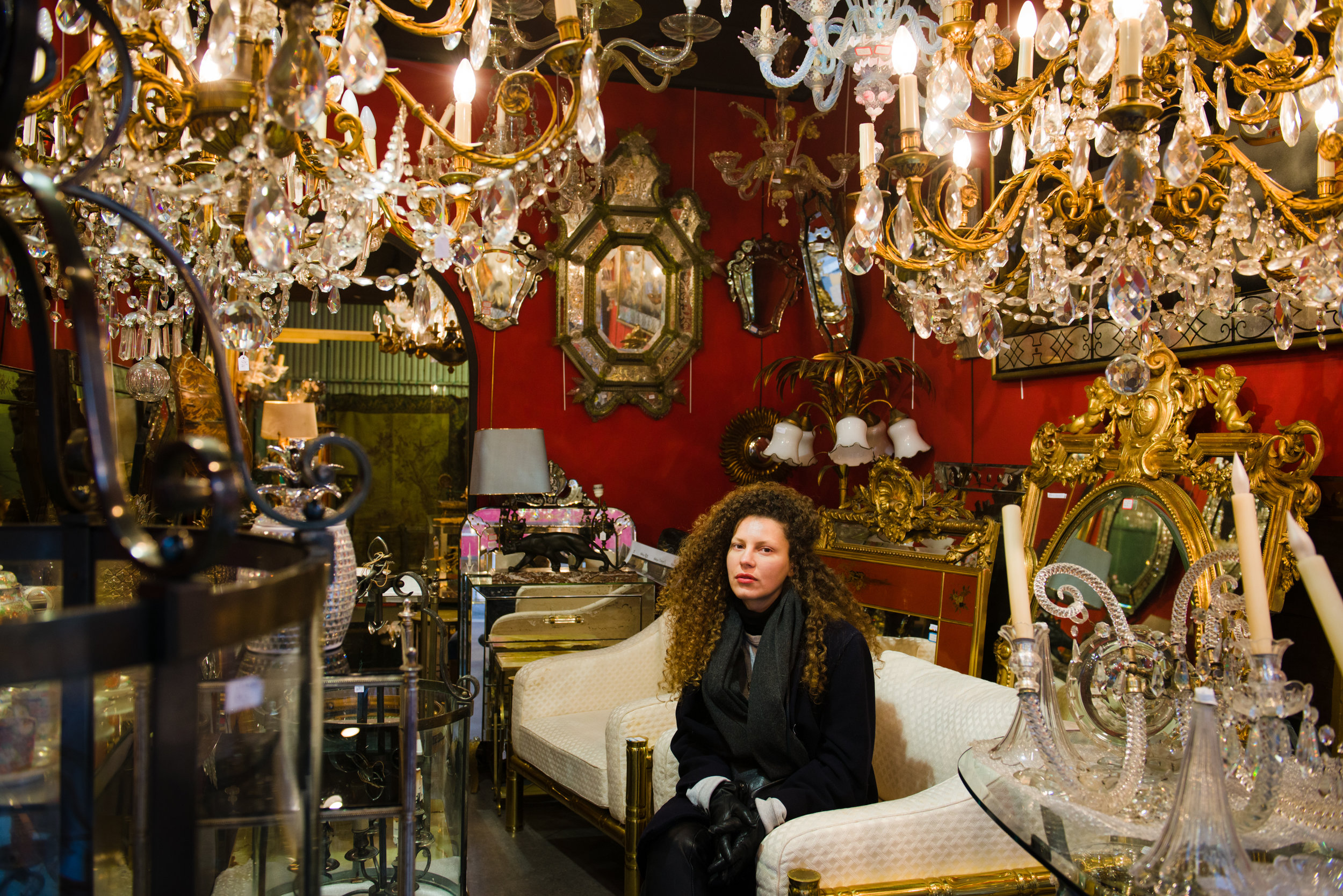 The subject is framed by the bric-a-brac of the store, in the Marché Aux Puces in Paris. Photo by William Lounsbury.