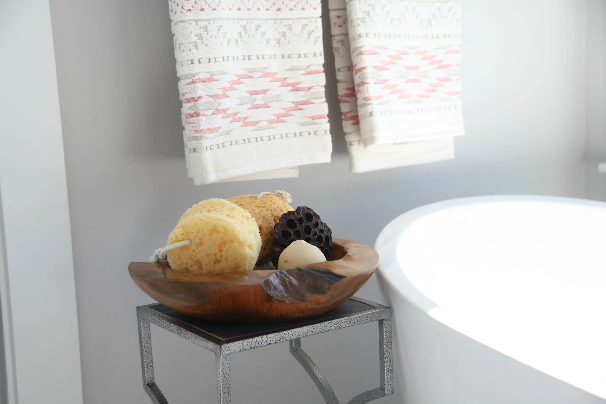 Rustic bowl with sponges next to a soaking tub is a must.