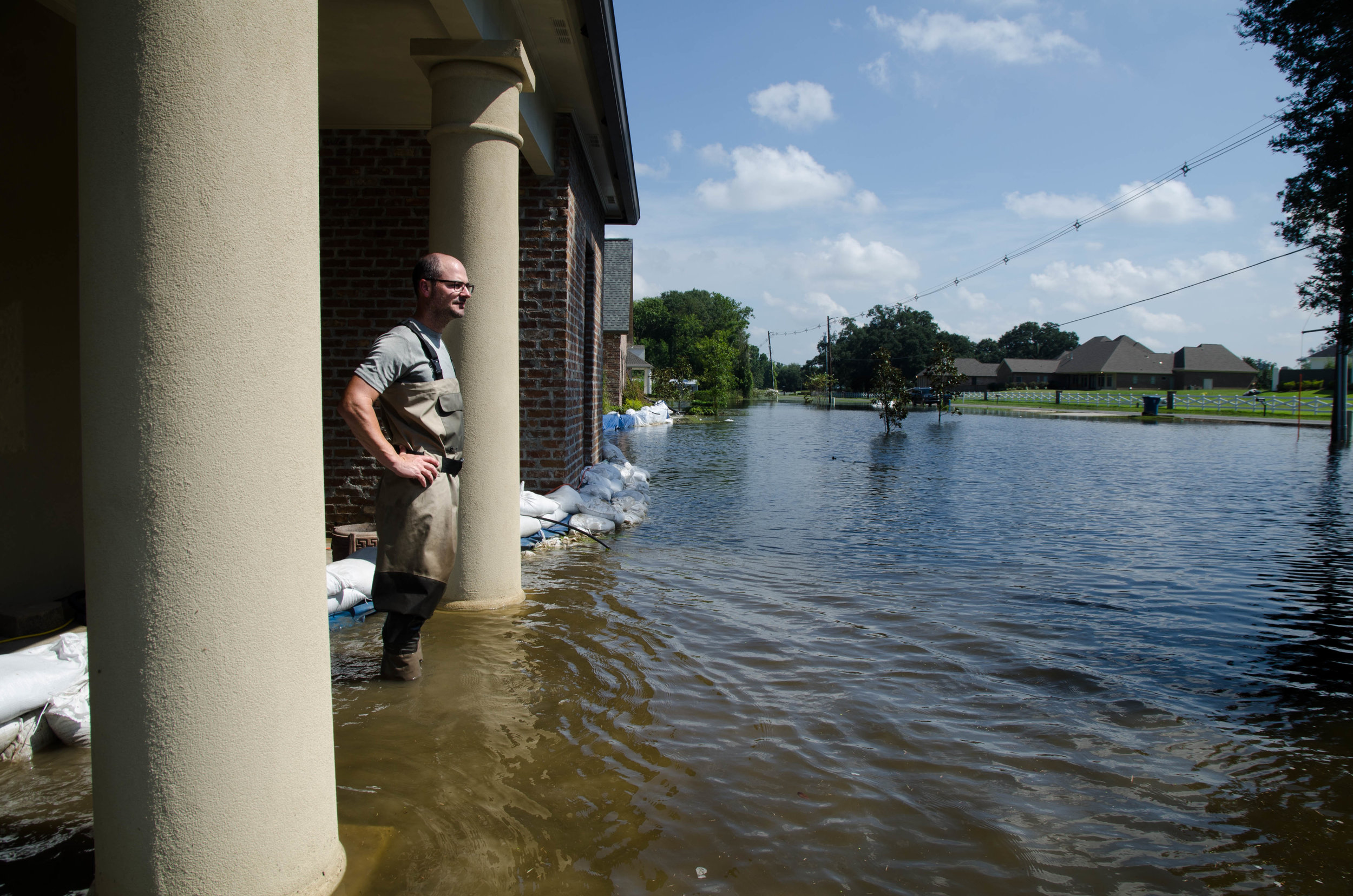  Nicholar Gros stands on his front porch, looking out on his flooded Baton Rouge neighborhood. 