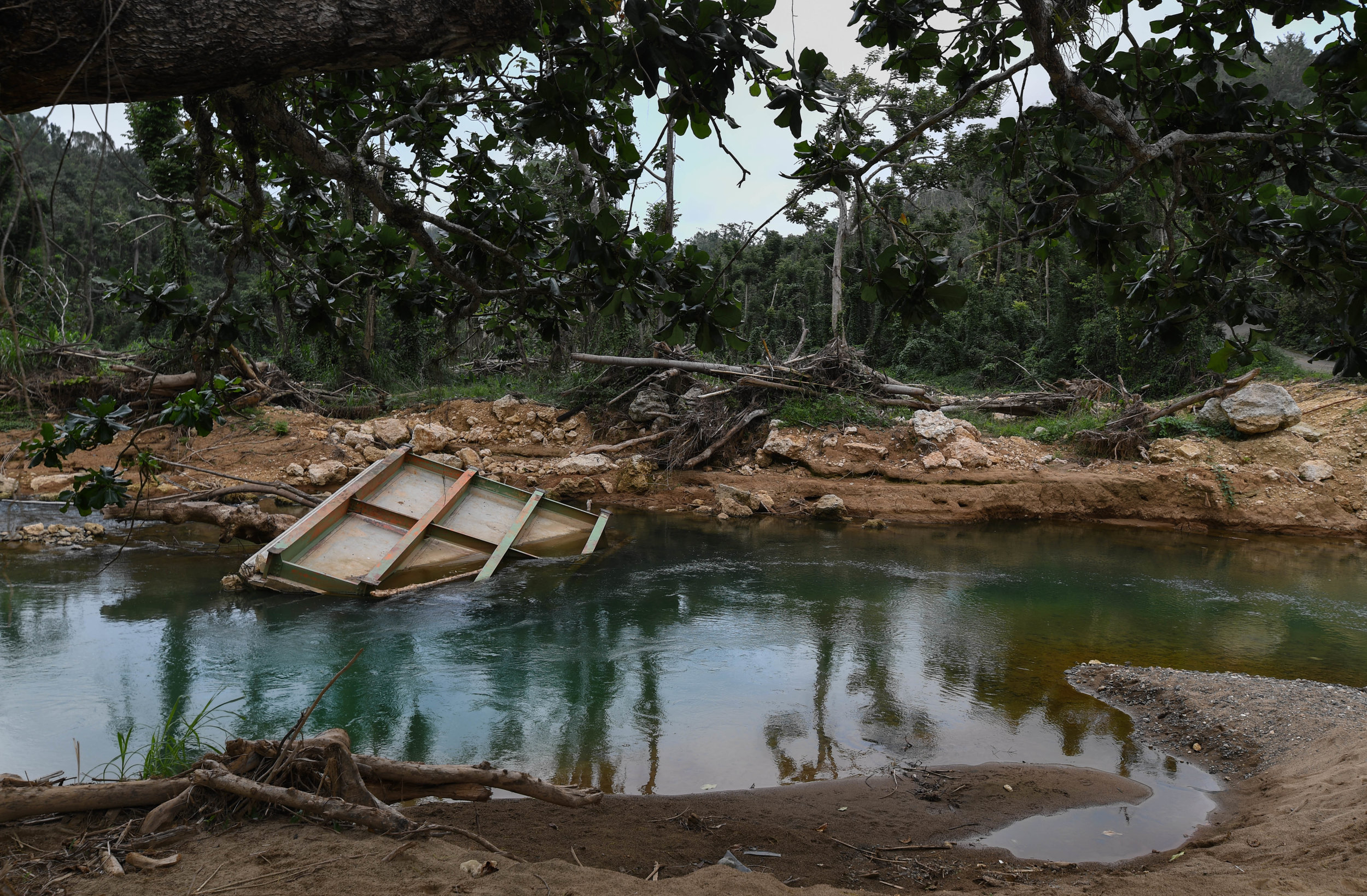  A piece of a concrete bridge floats down a river in the mountains of Puerto Rico. 