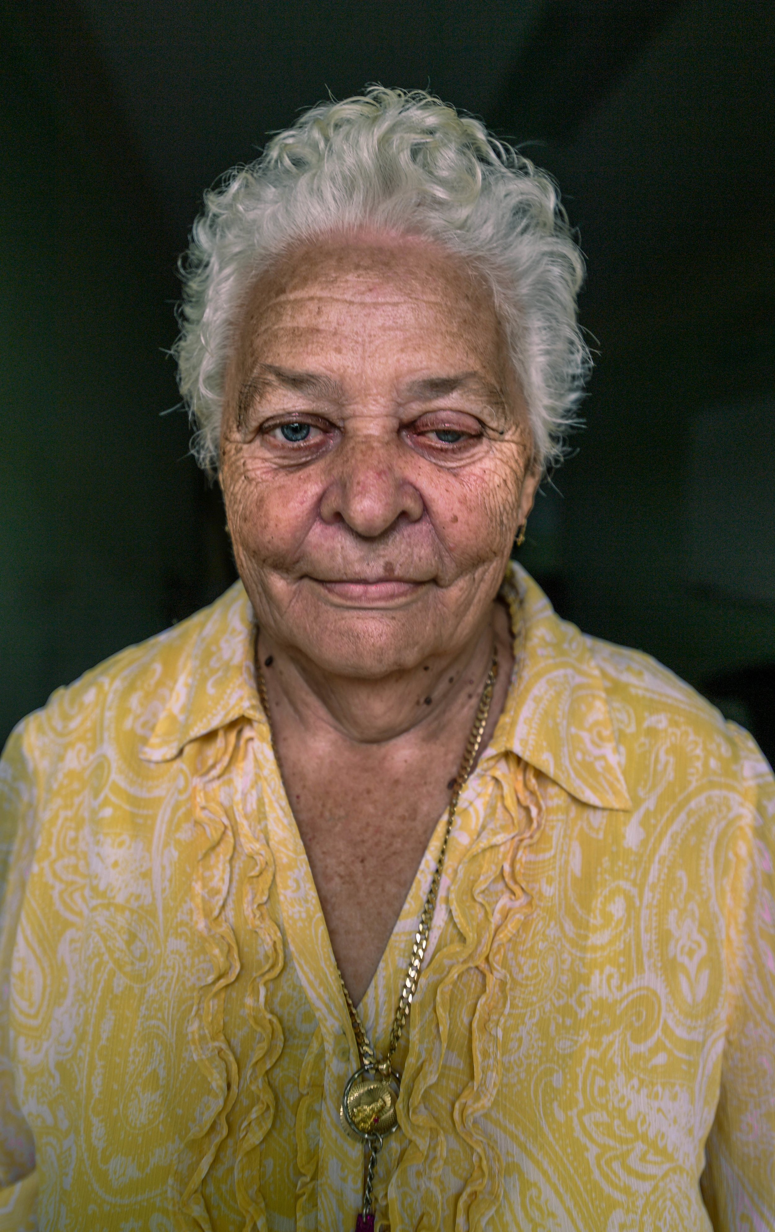  Josefina Adonte, 71, stands in her room at the Adjuntas shelter. Before the storm, Adonte was living in assisted care. Now, she struggles to take care of herself in the shelter with no nurse. Because of glaucoma and dementia, Adonte cannot complete 