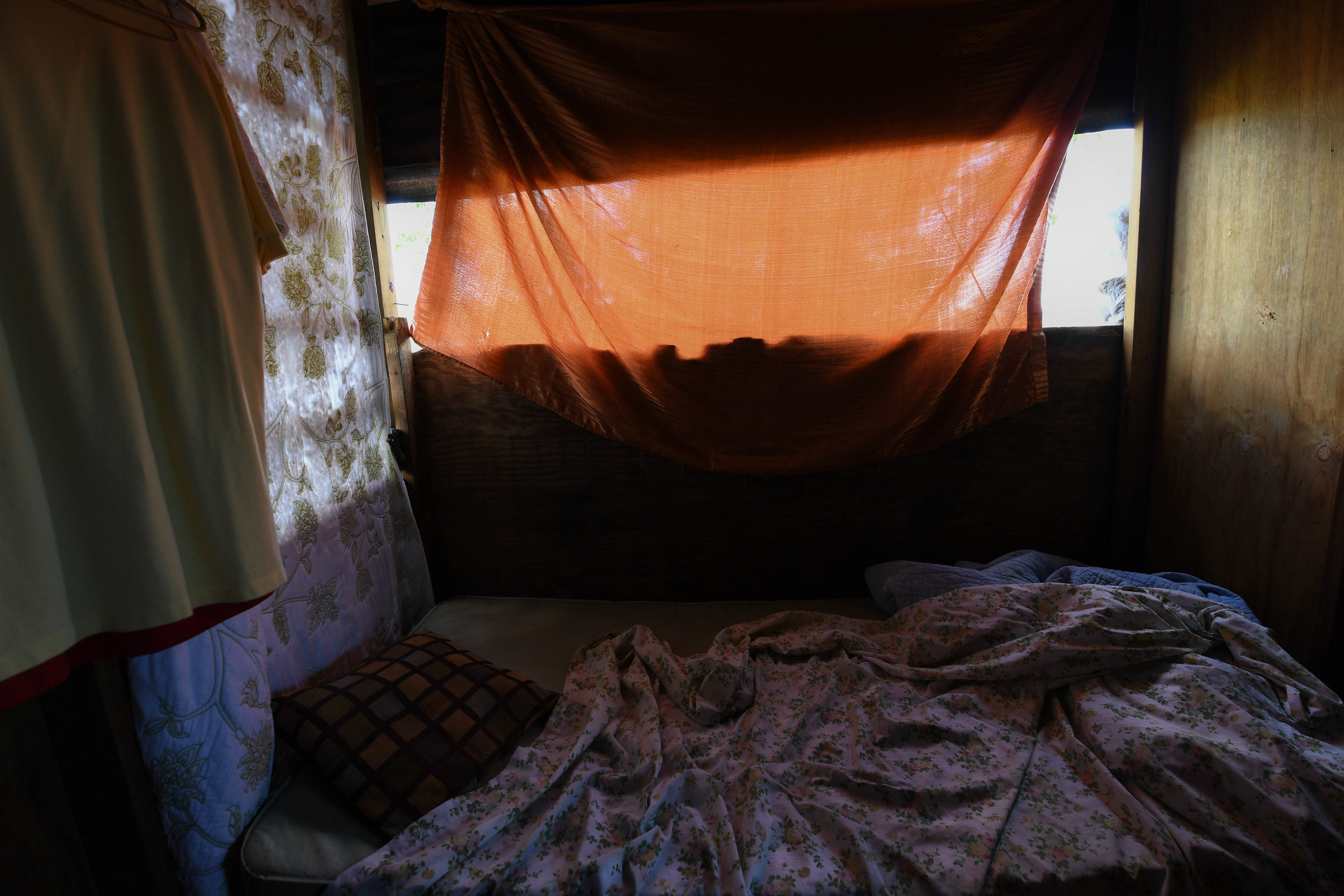   Paola Ortiz's home in Moca, including her bedroom, was pulled apart by the wind during Maria. All her walls, windows and clothes were lost. Over the past three months, she has rebuilt her home with plywood and tarp. 