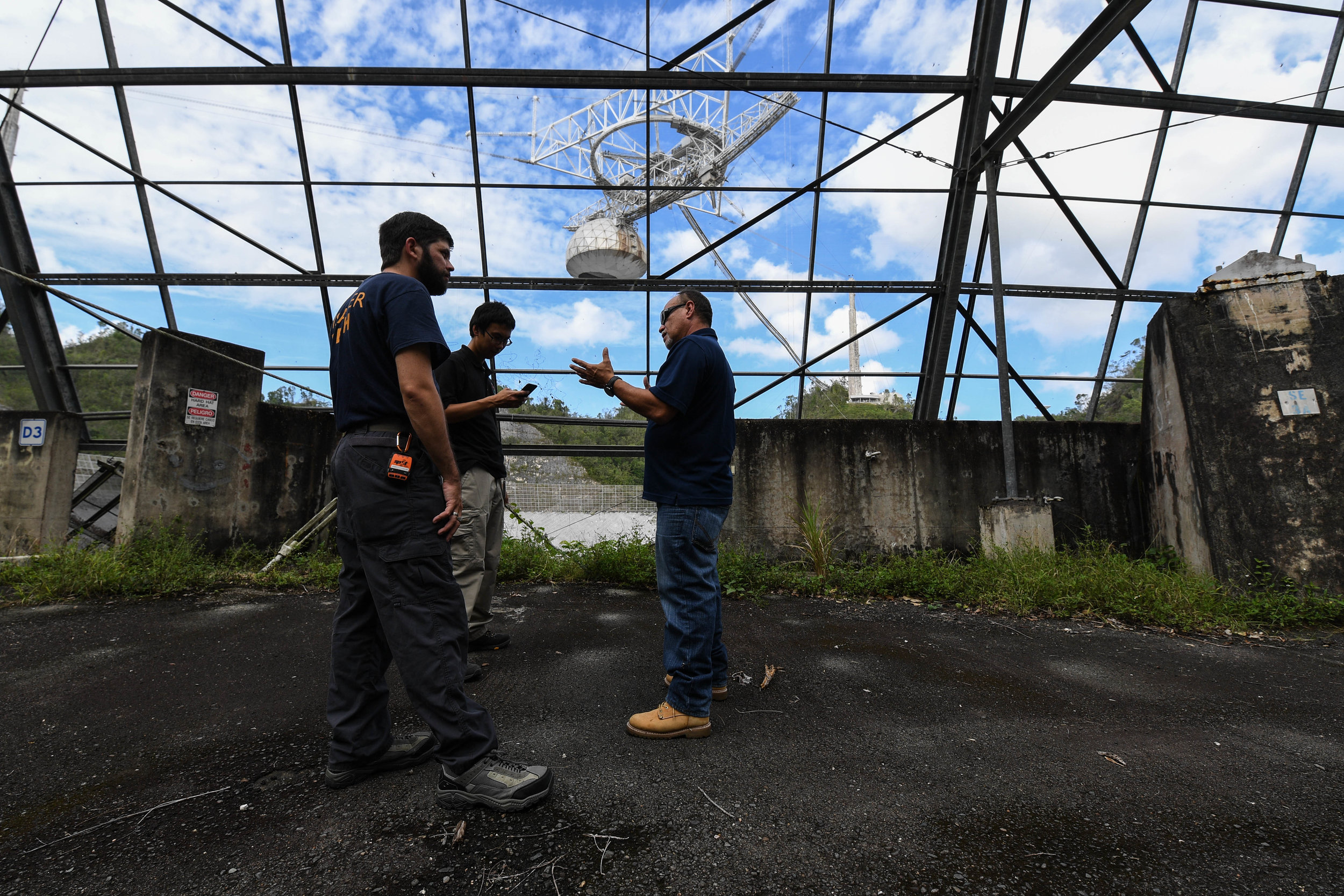  Dustin Lee and Darrick Kouns, volunteers for ITDRC, speak with Israel Cabrera about how the equipment is working since getting the Arecibo Observatory back online. ITDRC reconnected the observatory. The observatory is the second biggest in the world