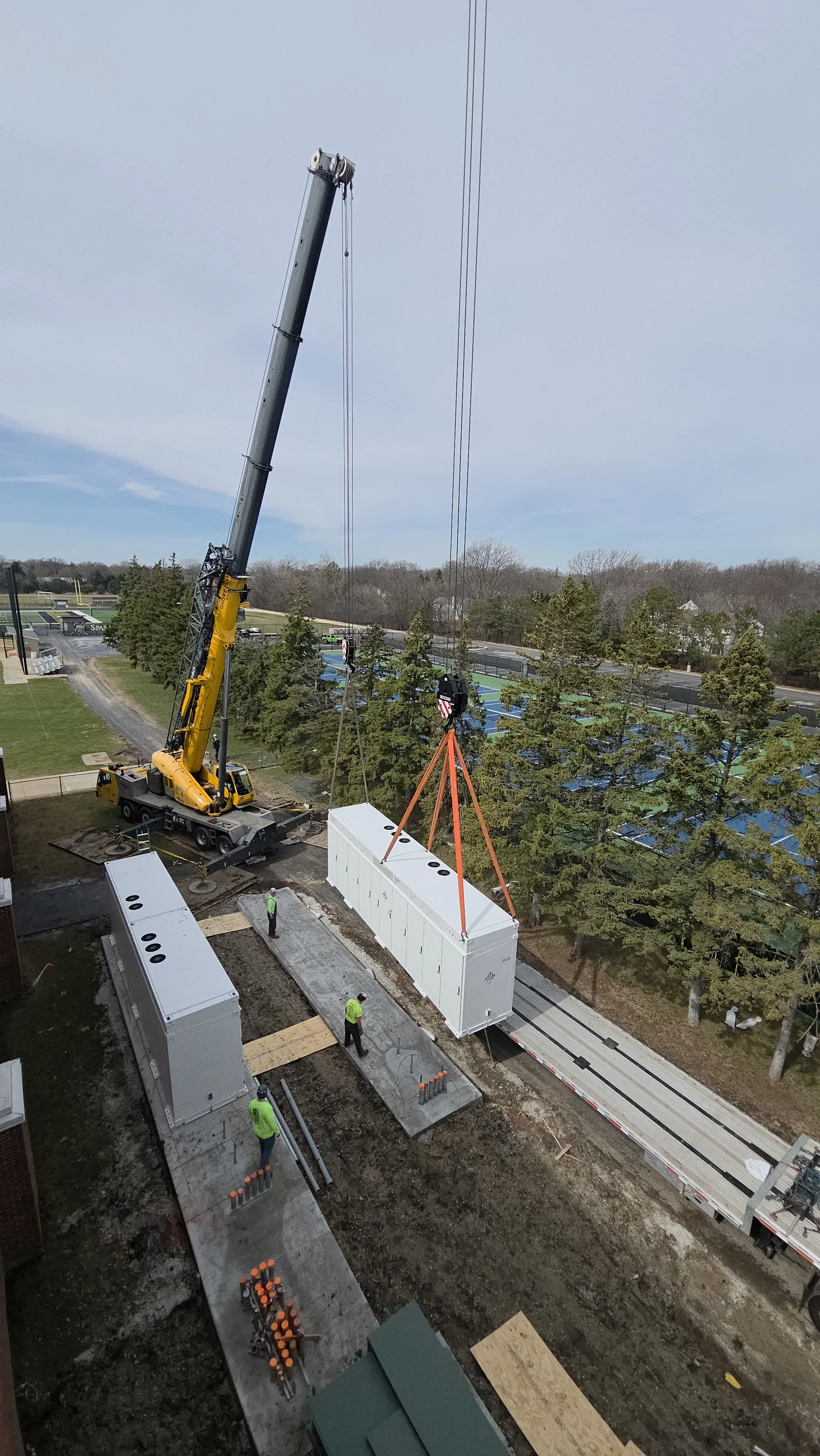Crane lifting Tesla Megapack 2XL energy storage battery at Glenbrook North High School