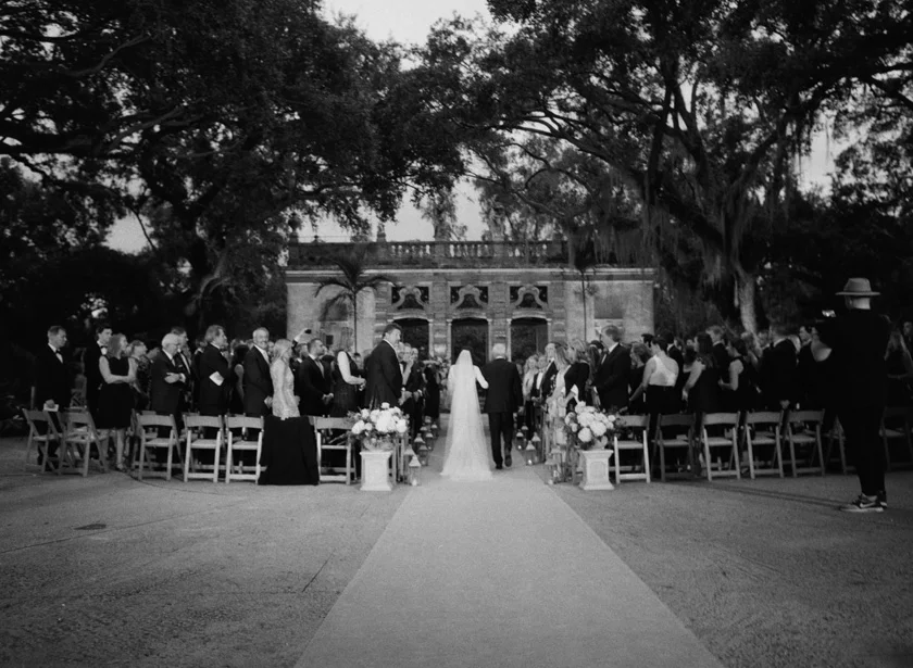 Bride walking into Vizcaya wedding ceremony with her dad