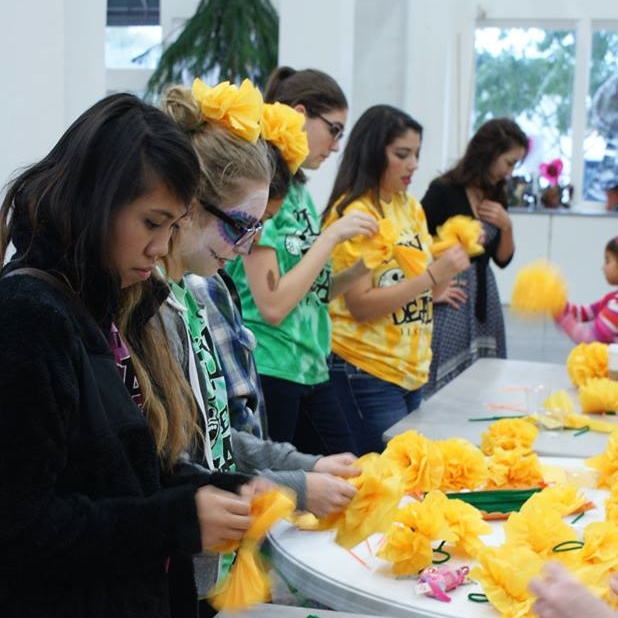 Volunteers assist visitors making paper marigolds during Denton's Day of the Dead Festival at the Arts Center.