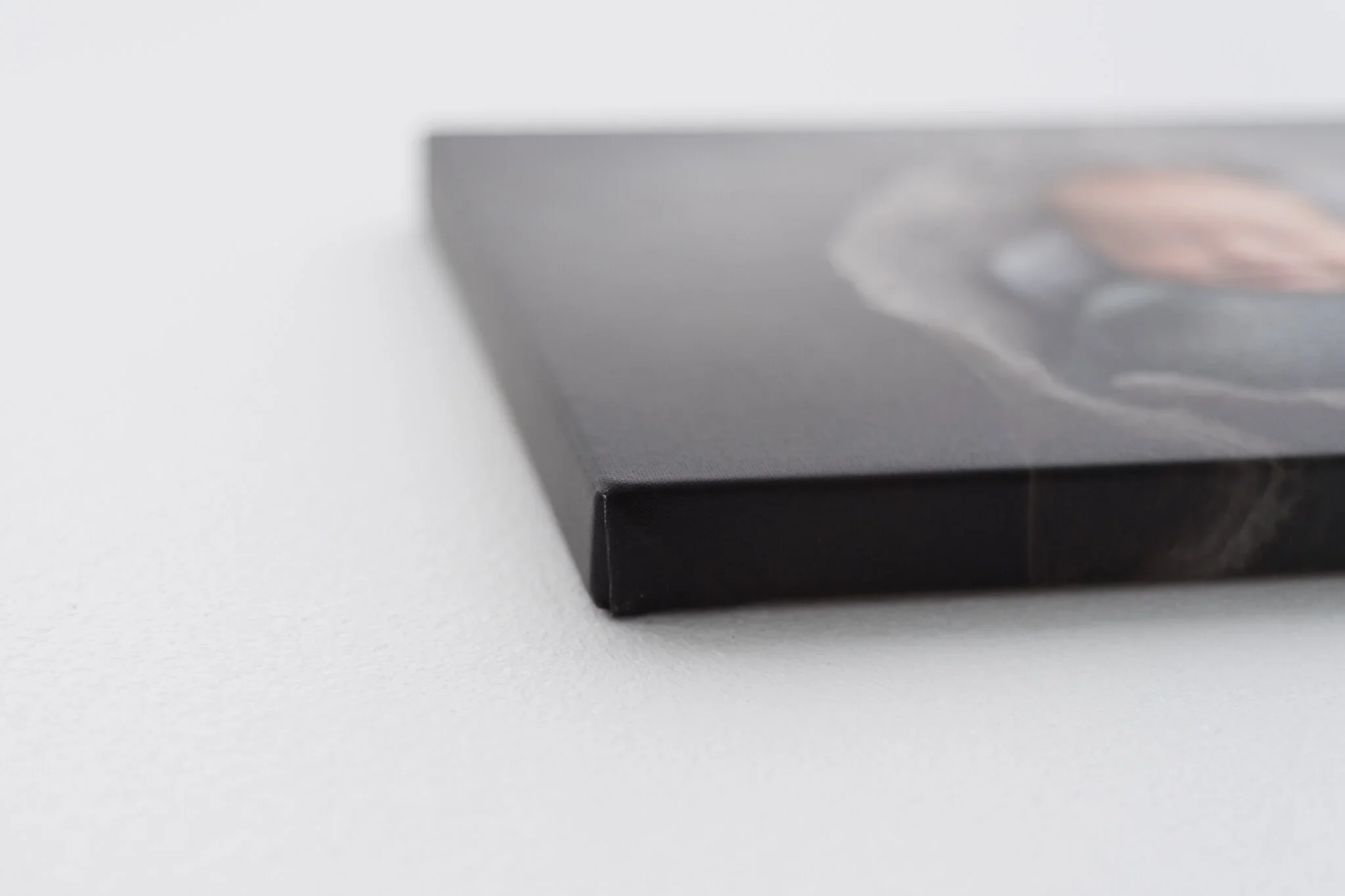 Close-up of a black box with a blurred image on top, resting on a white surface.