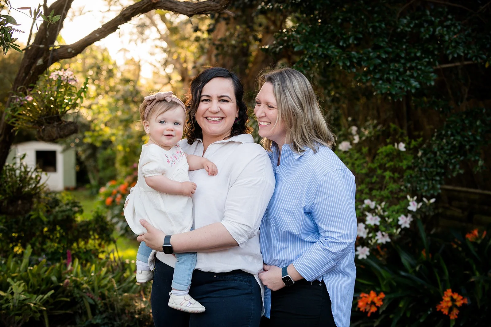 Two mums looking lovingly at their toddler daughter