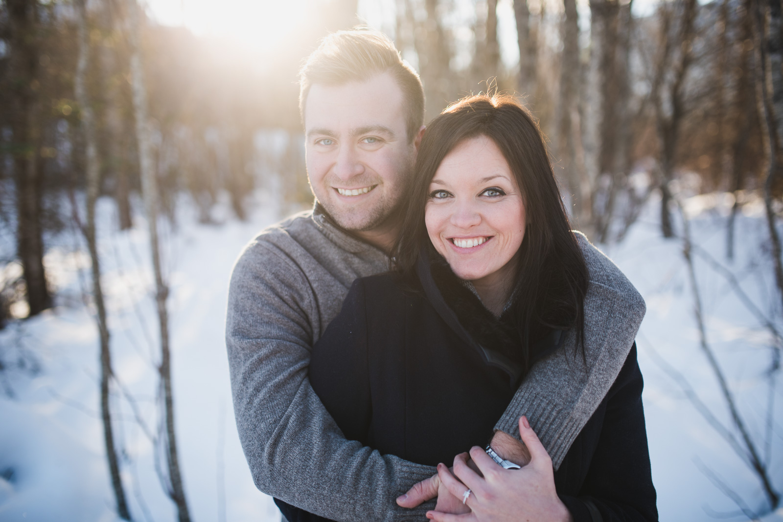 couple standing in the snow with sunflare behind them in whistler - vancouver island wedding photographers