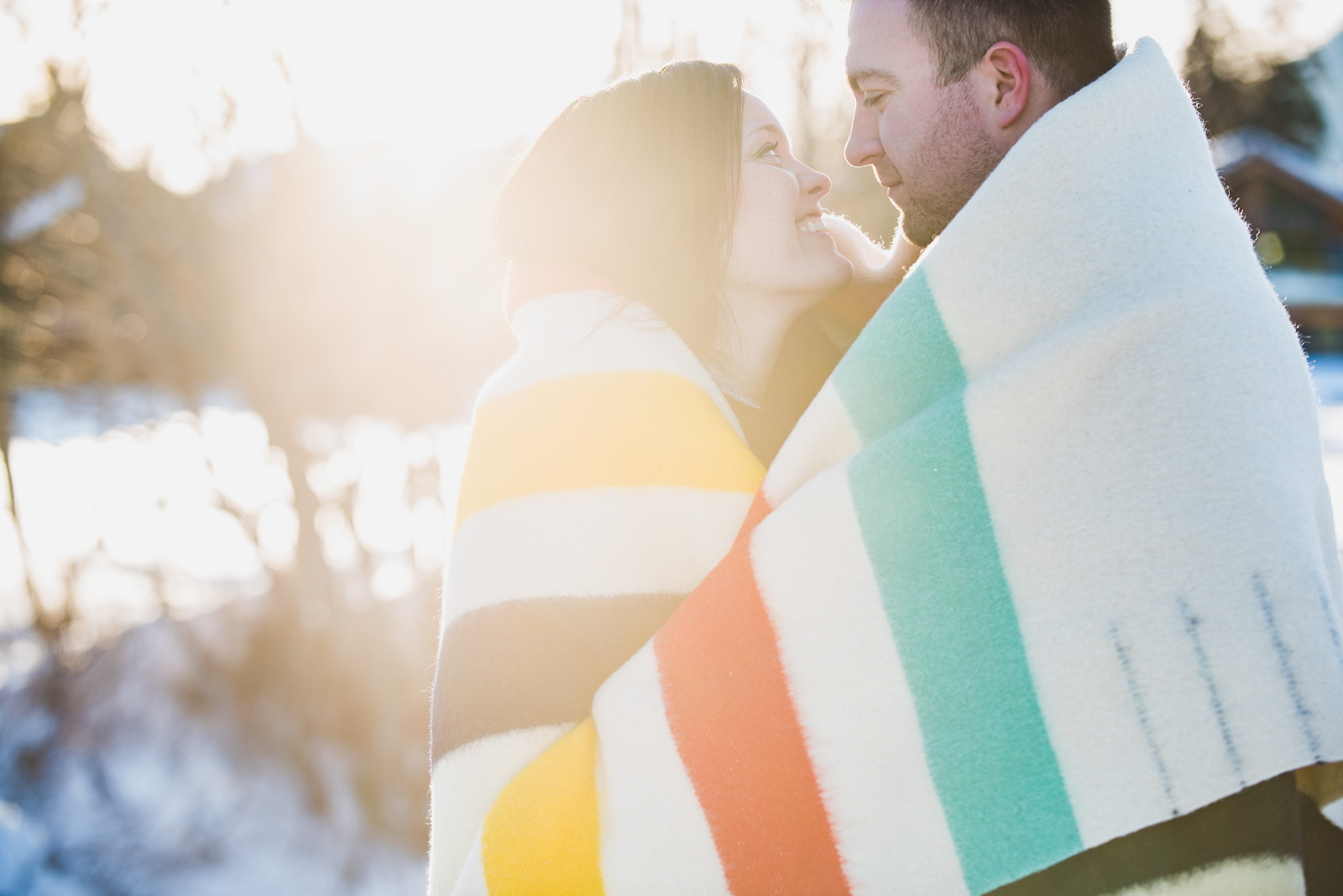 couple standing in the sun wrapped in HBC blanket in the winter - vancouver island wedding photographers