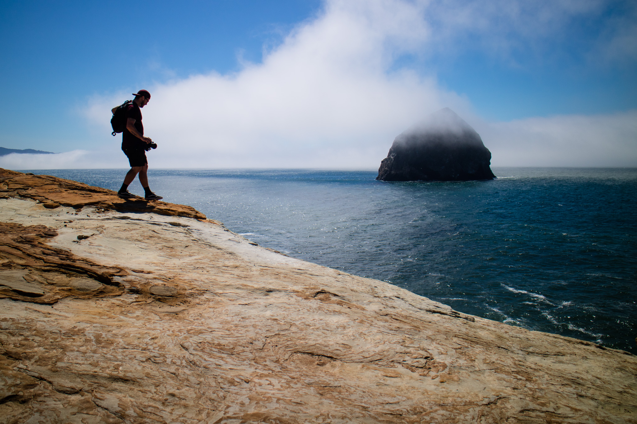 Larryn walking with Haystack Rock in the background.