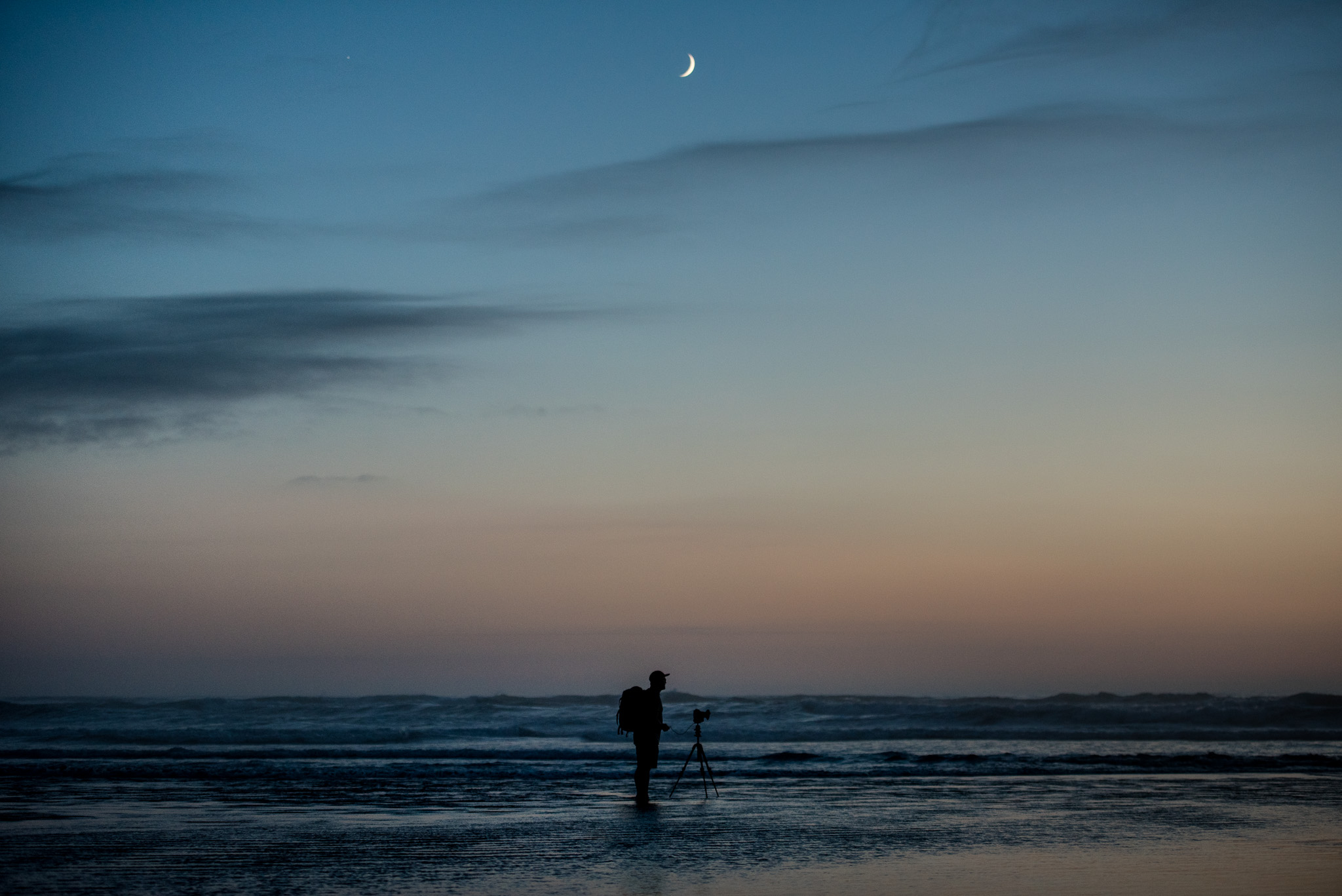  A neat portrait of Larryn standing in the water after sunset with the moon above him, getting his angle at Cannon Beach.&nbsp;&nbsp;    