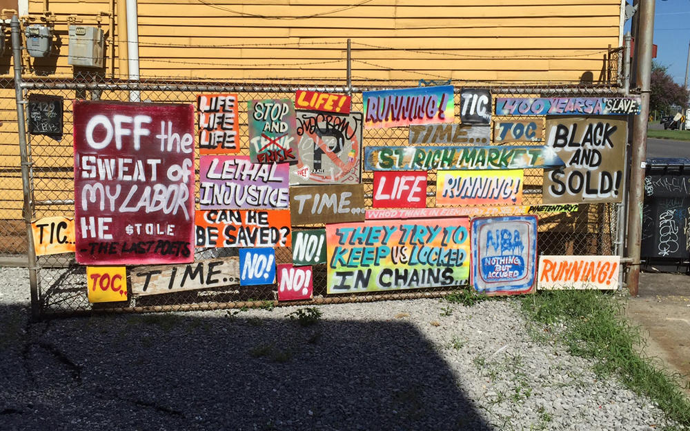 INSTALLATION VIEW OF PAINTINGS BY DEVIN REYNOLDS OUTSIDE OF UNO ST. CLAUDE GALLERY AS PART OF “#REHUMANIZE, FOR ALBERT WOODFOX.”
