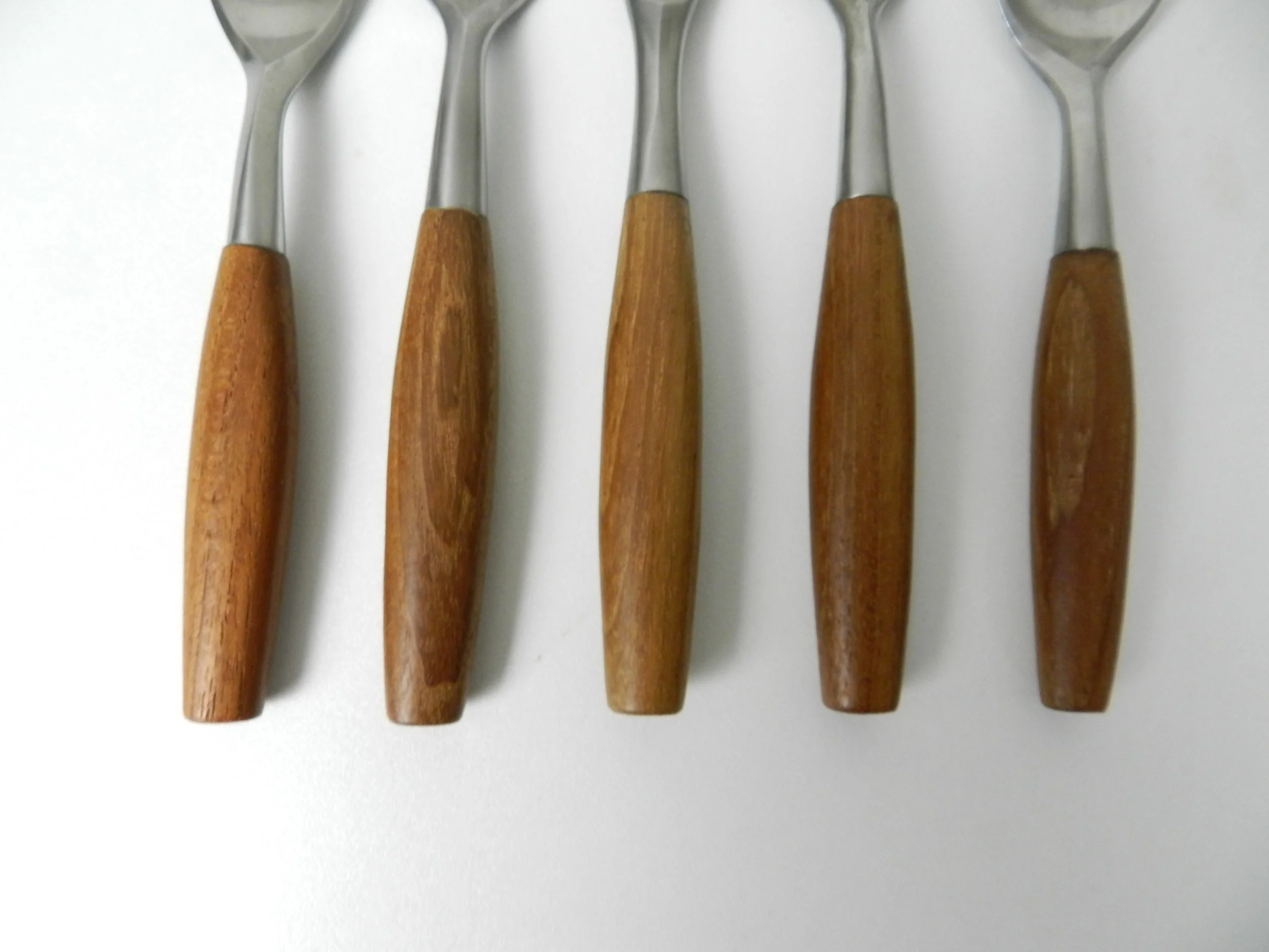 Set of Fjord flatware designed by Jens Quistgaard for Dansk. Stainless steel with teak handles. 6 complete place setttings of 5 plus one serving utensil, 31 pieces total.  Germany, 1960s.