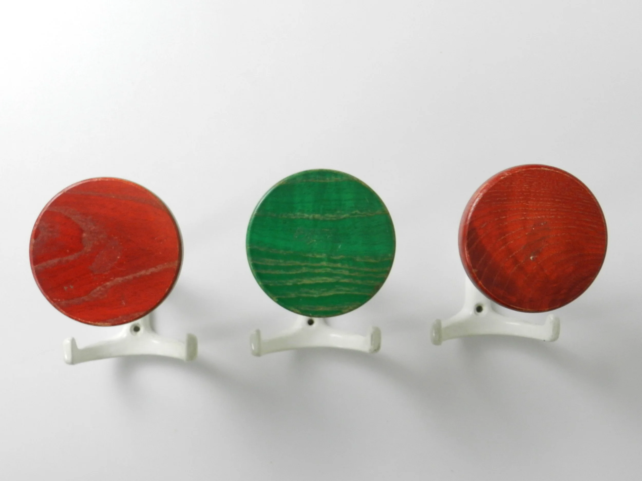 Set of three mid century coat hooks in enameled metal and wood.  Germany, 1970s.