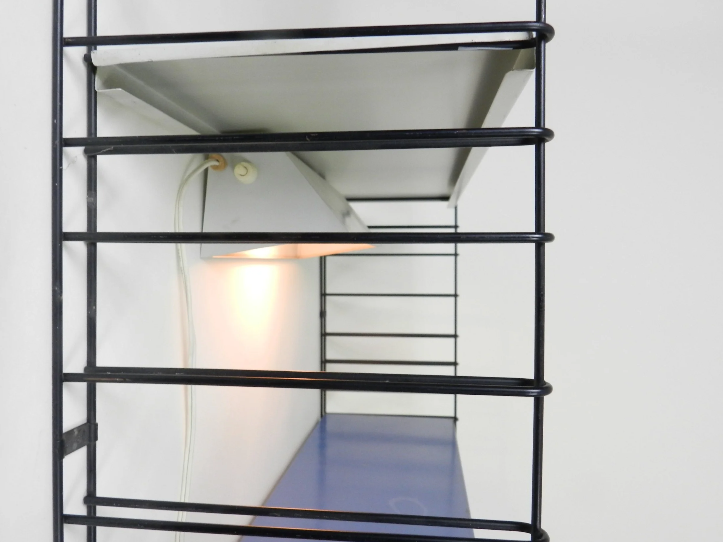 Mid century metal wall mount shelving unit with lamp  by Tomado.  Netherlands, 1960s.