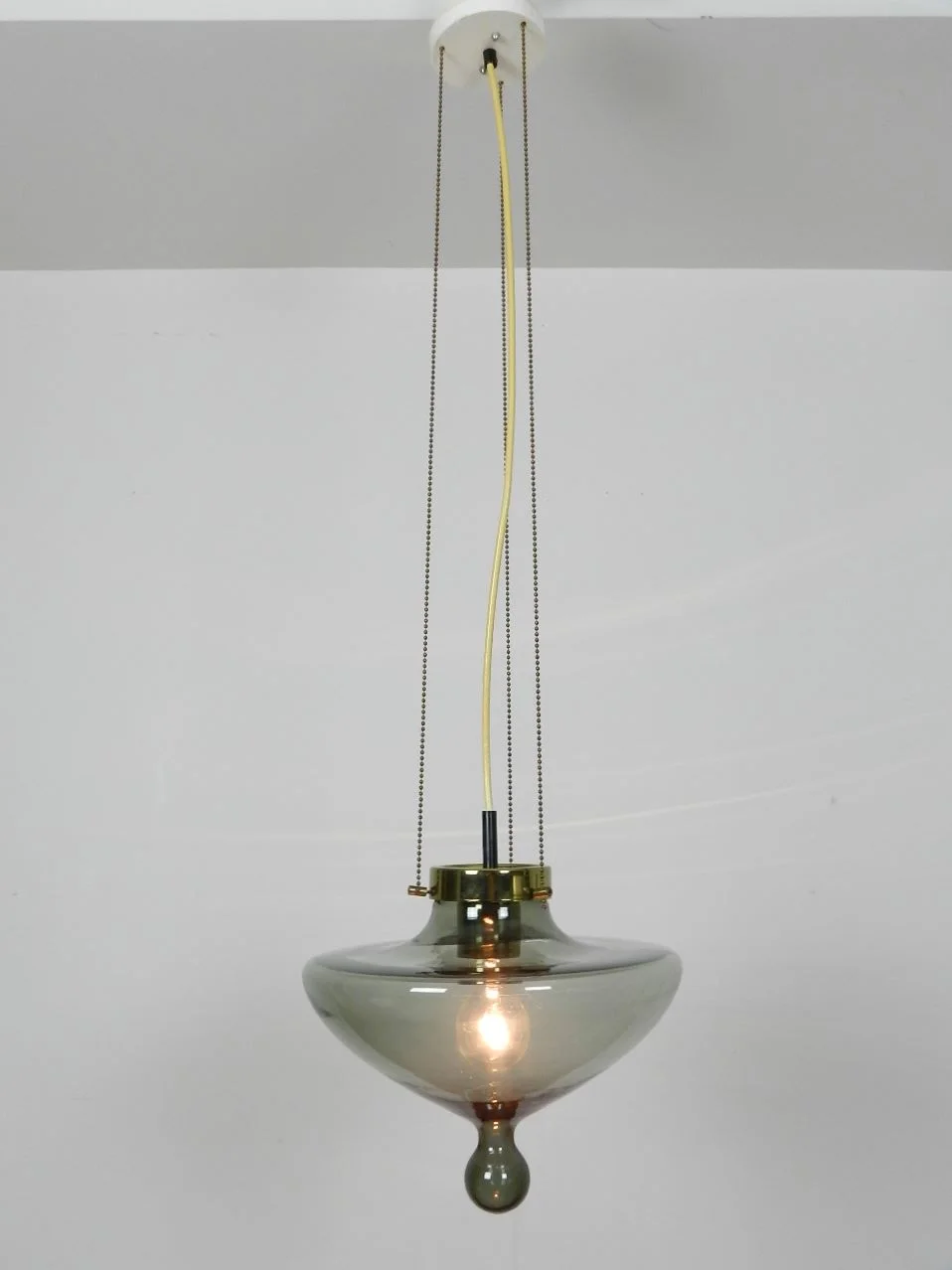 Pendant lamp by Raak. Smoked glass shade with bronze colored hardware.  Netherlands, 1960s.