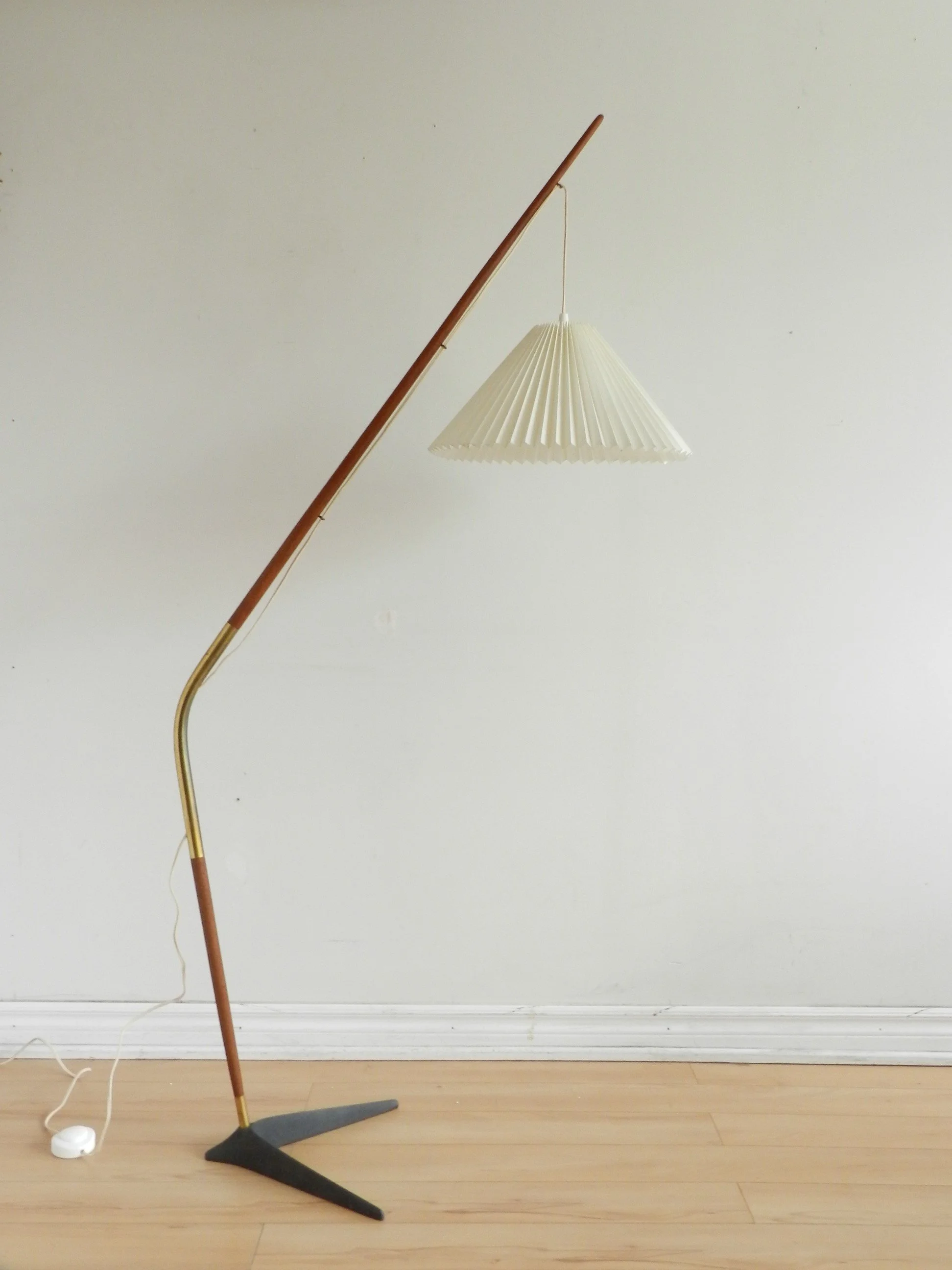 Fishing pole floor lamp in teak and brass with cast metal base and pleated shade. Designed by Svend Aage Holm Sorensen.  Denmark, 1960s.