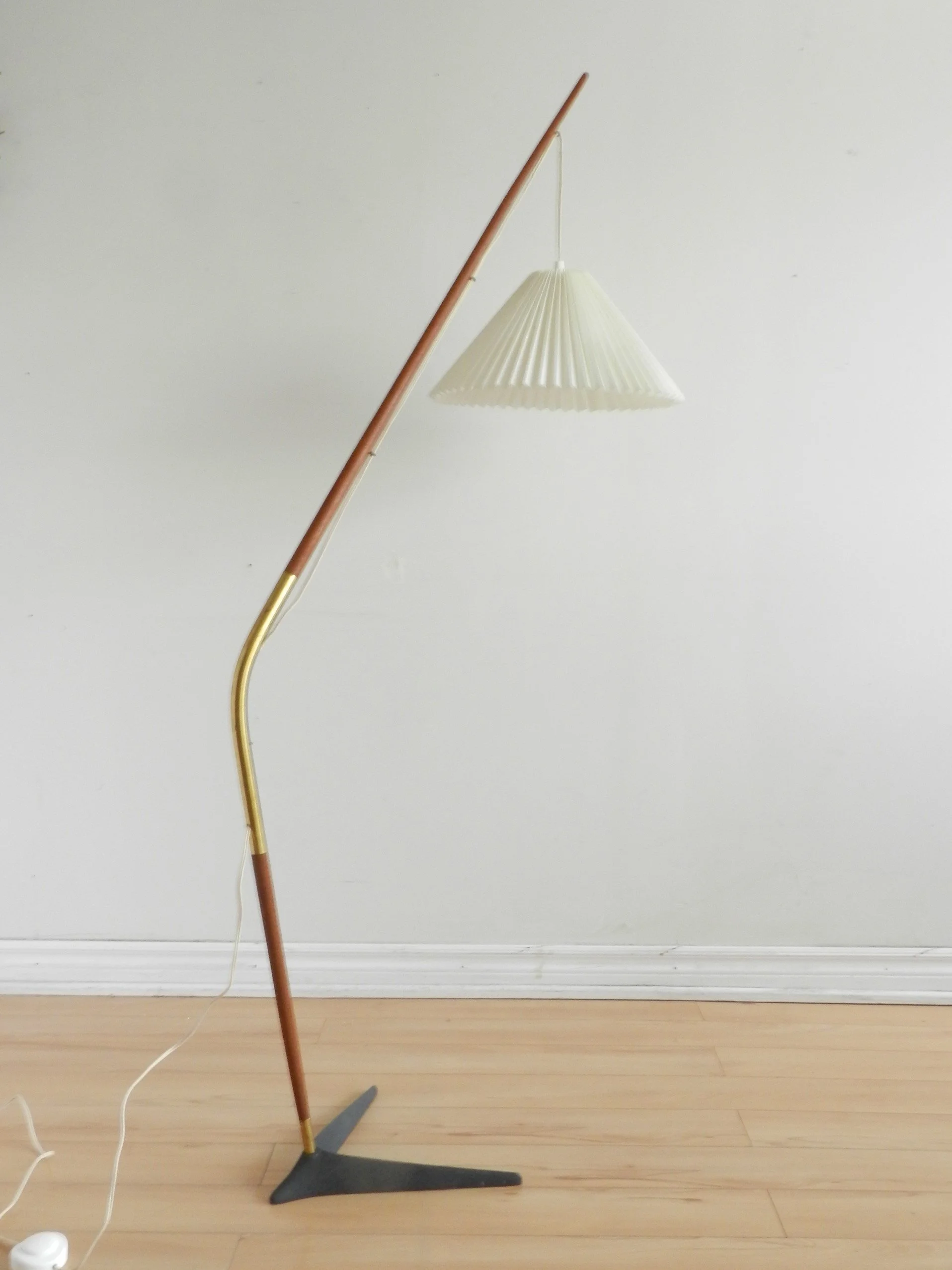 Fishing pole floor lamp in teak and brass with cast metal base and pleated shade. Designed by Svend Aage Holm Sorensen.  Denmark, 1960s.