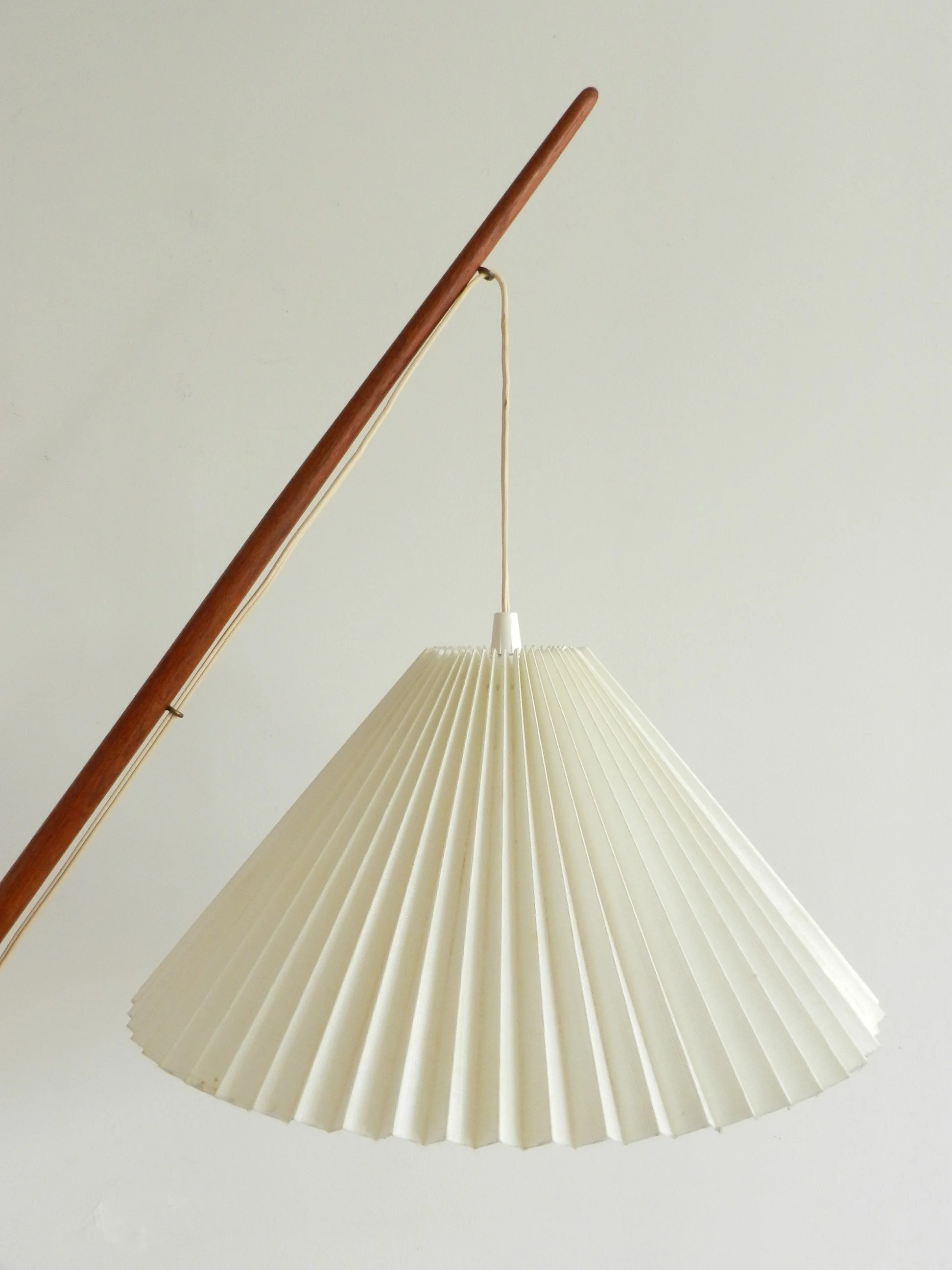 Fishing pole floor lamp in teak and brass with cast metal base and pleated shade. Designed by Svend Aage Holm Sorensen.  Denmark, 1960s.