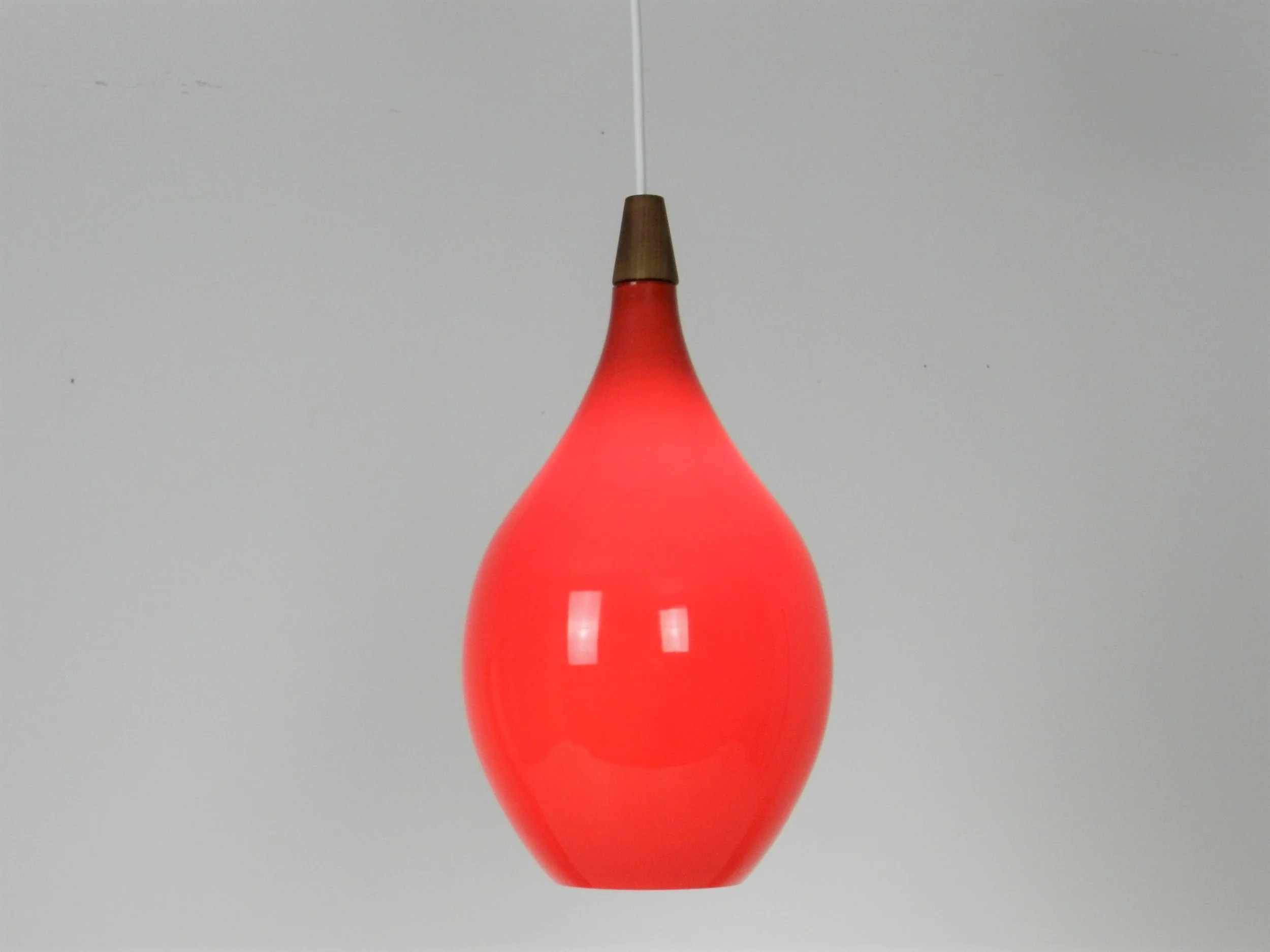 Red cased glass pendant lamp with teak finial by Holmegaard.  Denmark, 1960s.