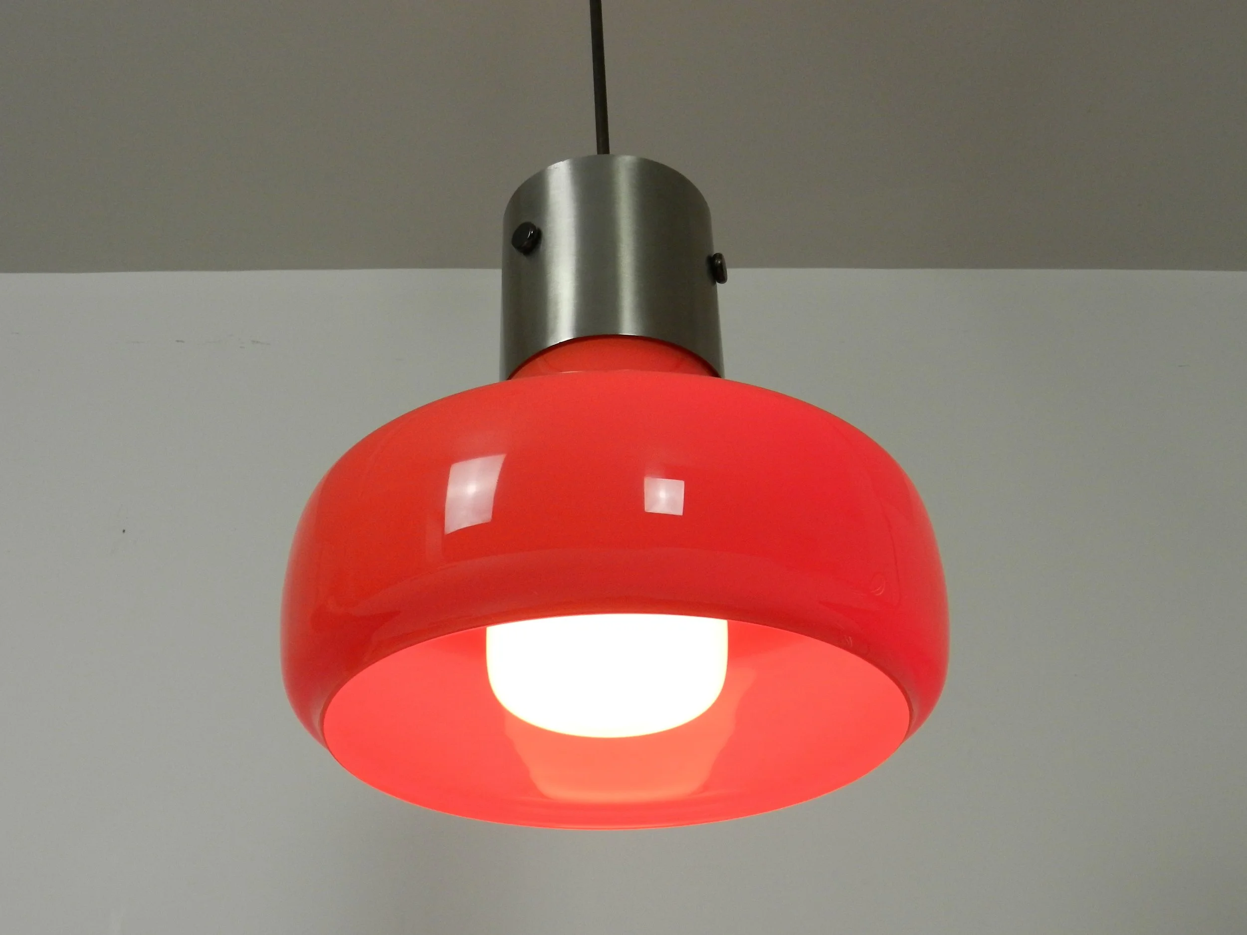 Space age pendant lamp in orange case glass with inner white glass shade and steel hardware.  Italy, 1970s.